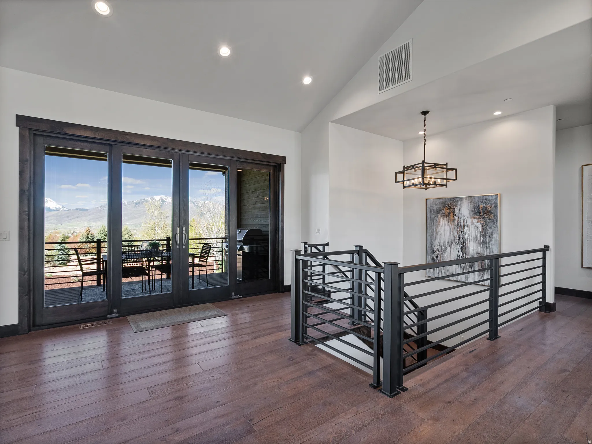 Stairs with hardwood / wood-style flooring, a mountain view, a high ceiling, and a chandelier