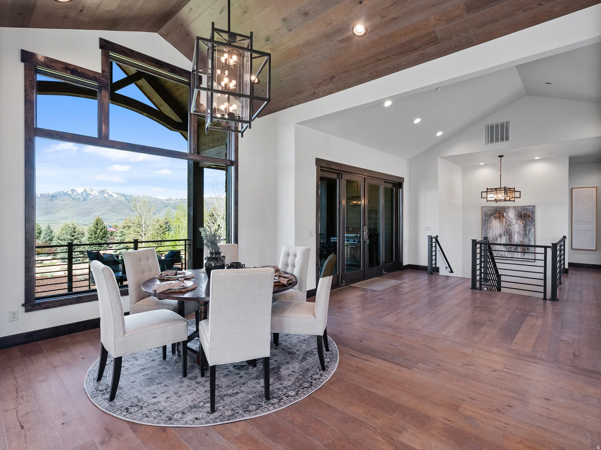 Dining room with hanging lights, a mountain view, hardwood / wood-style flooring, and a high wood ceiling