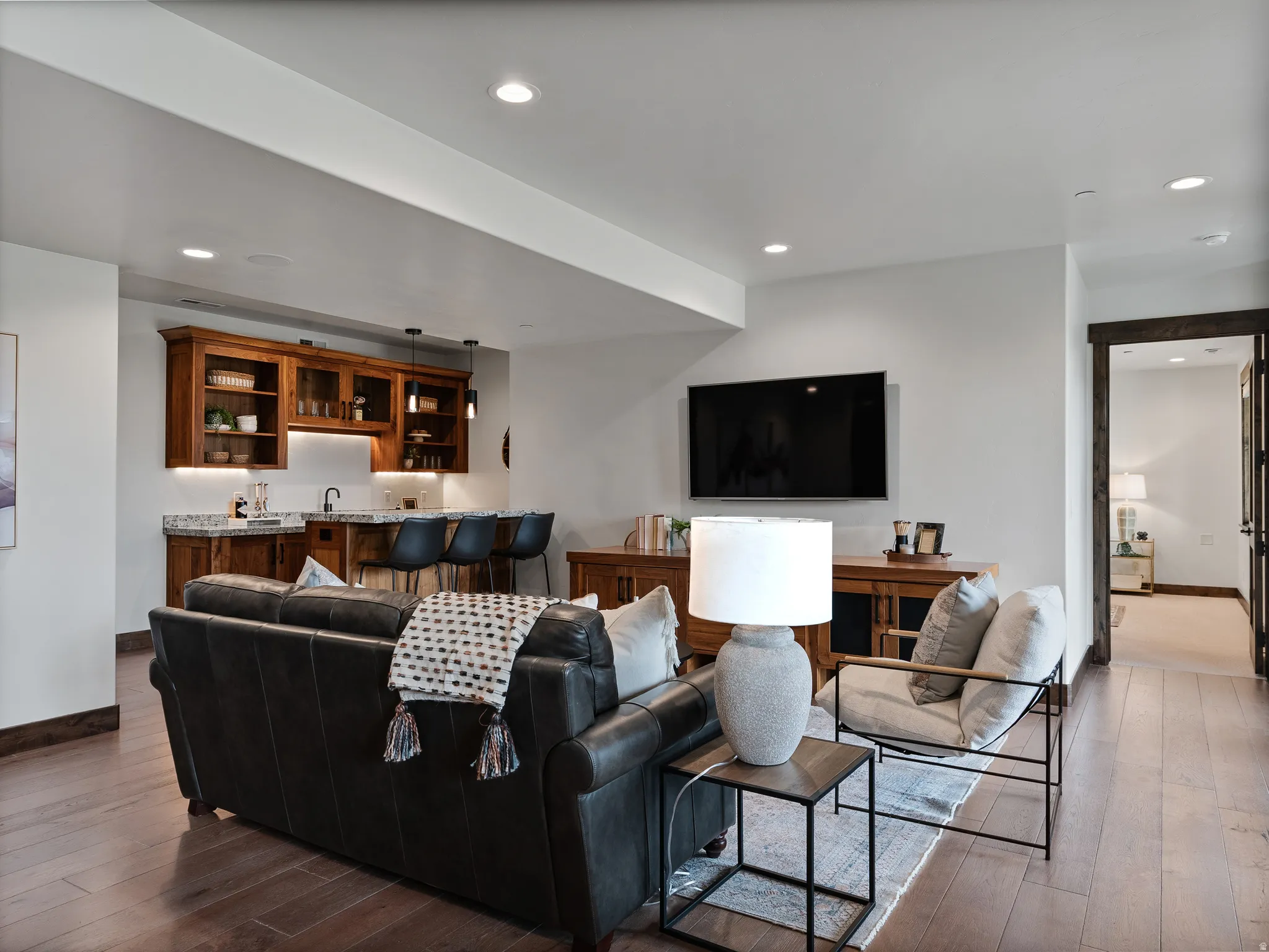 Living area with dark wood-type flooring, recessed lighting, and wet bar