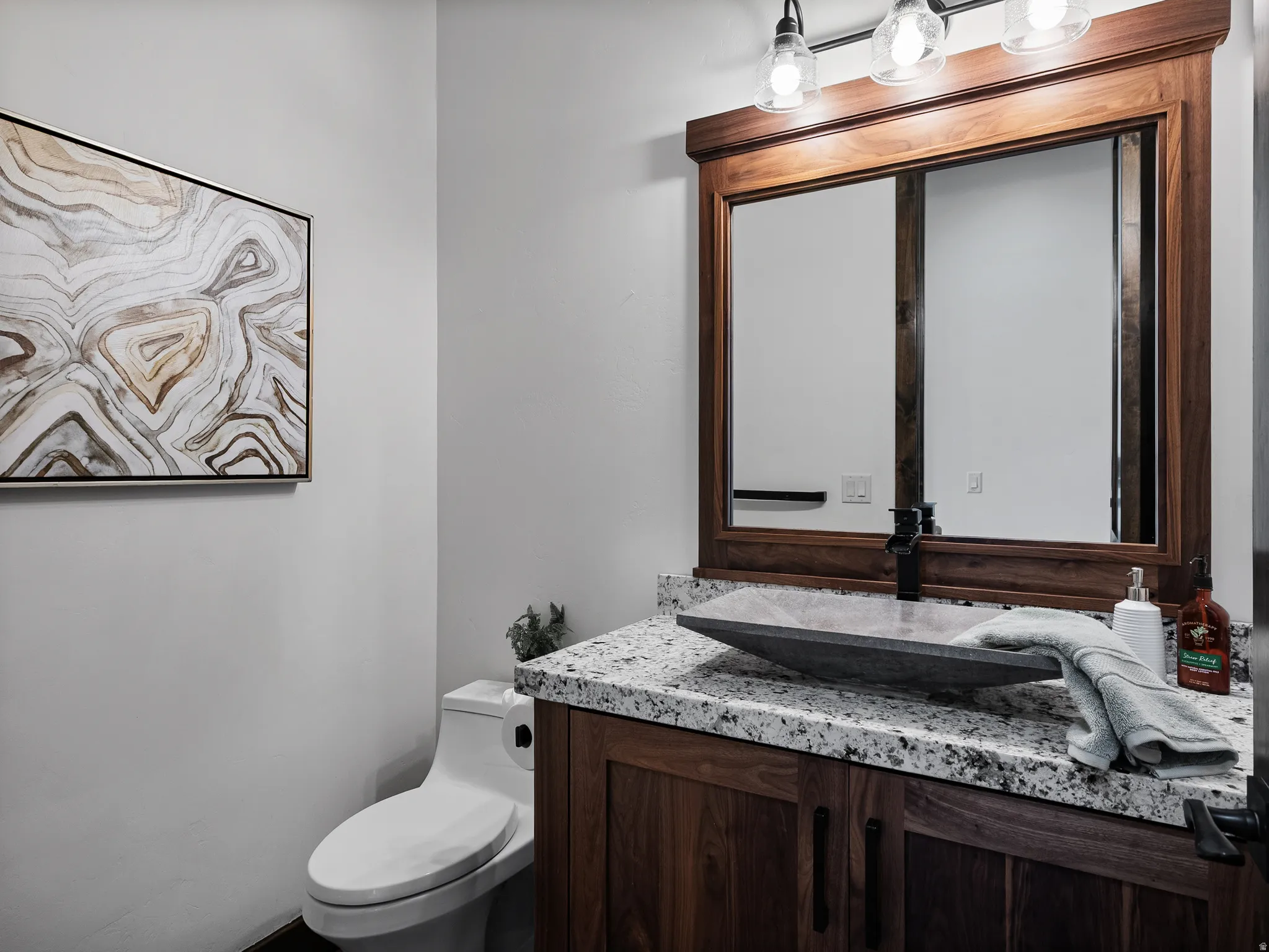 Half bathroom featuring vanity and toilet