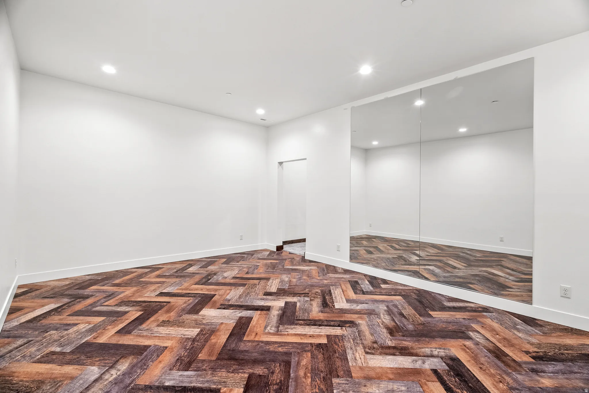 Spare room featuring parquet floors and recessed lighting