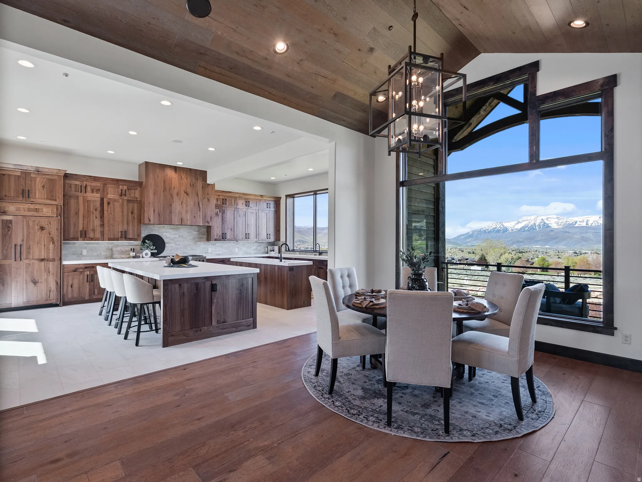 Dining area featuring a mountain view, a high wood ceiling, light wood finished floors, and suspended lighting