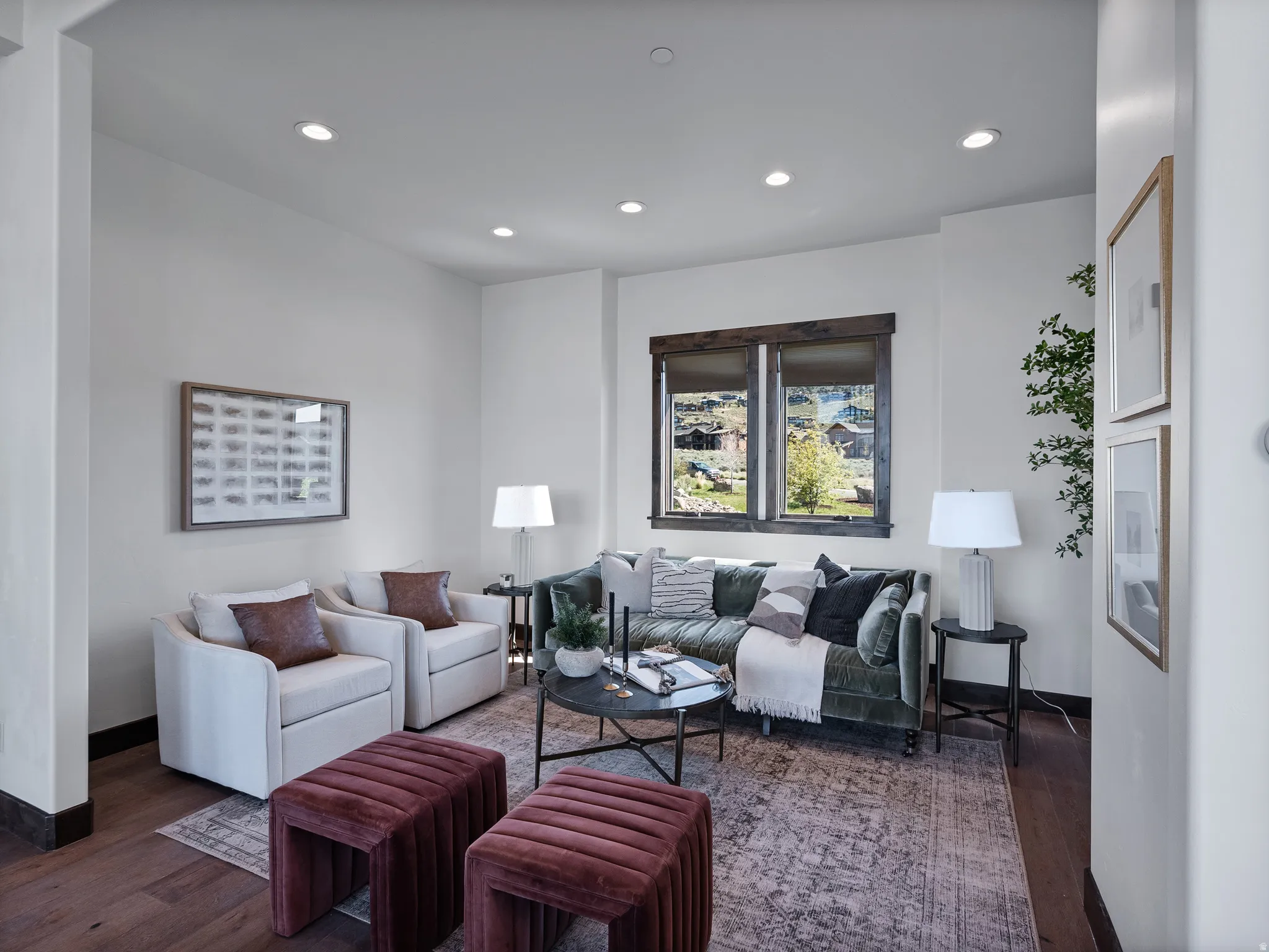 Spacious living area featuring recessed lighting, a large window with distressed wood trim, wood-finish flooring, and white wall finishes