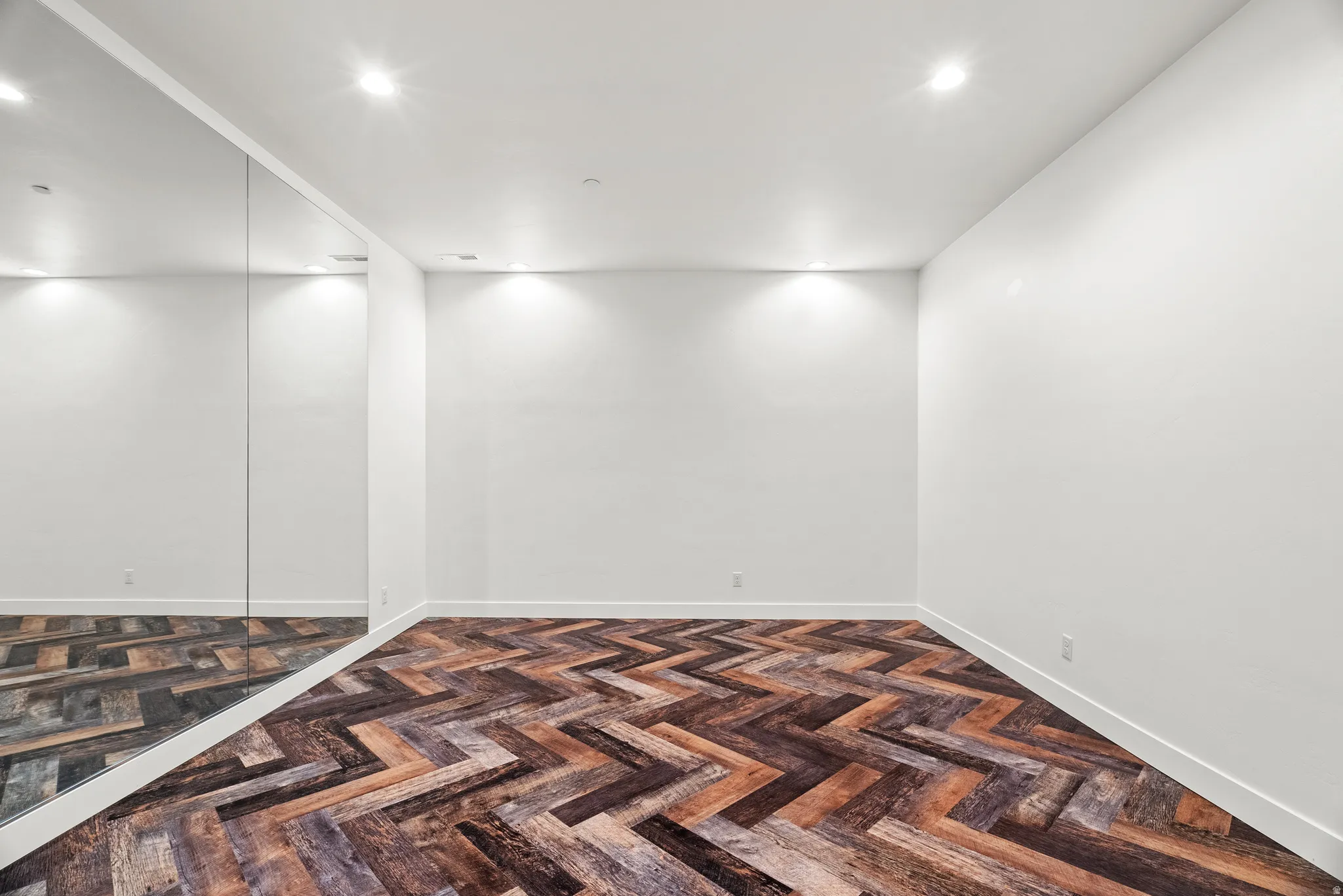 Spare room featuring parquet floors and recessed lighting