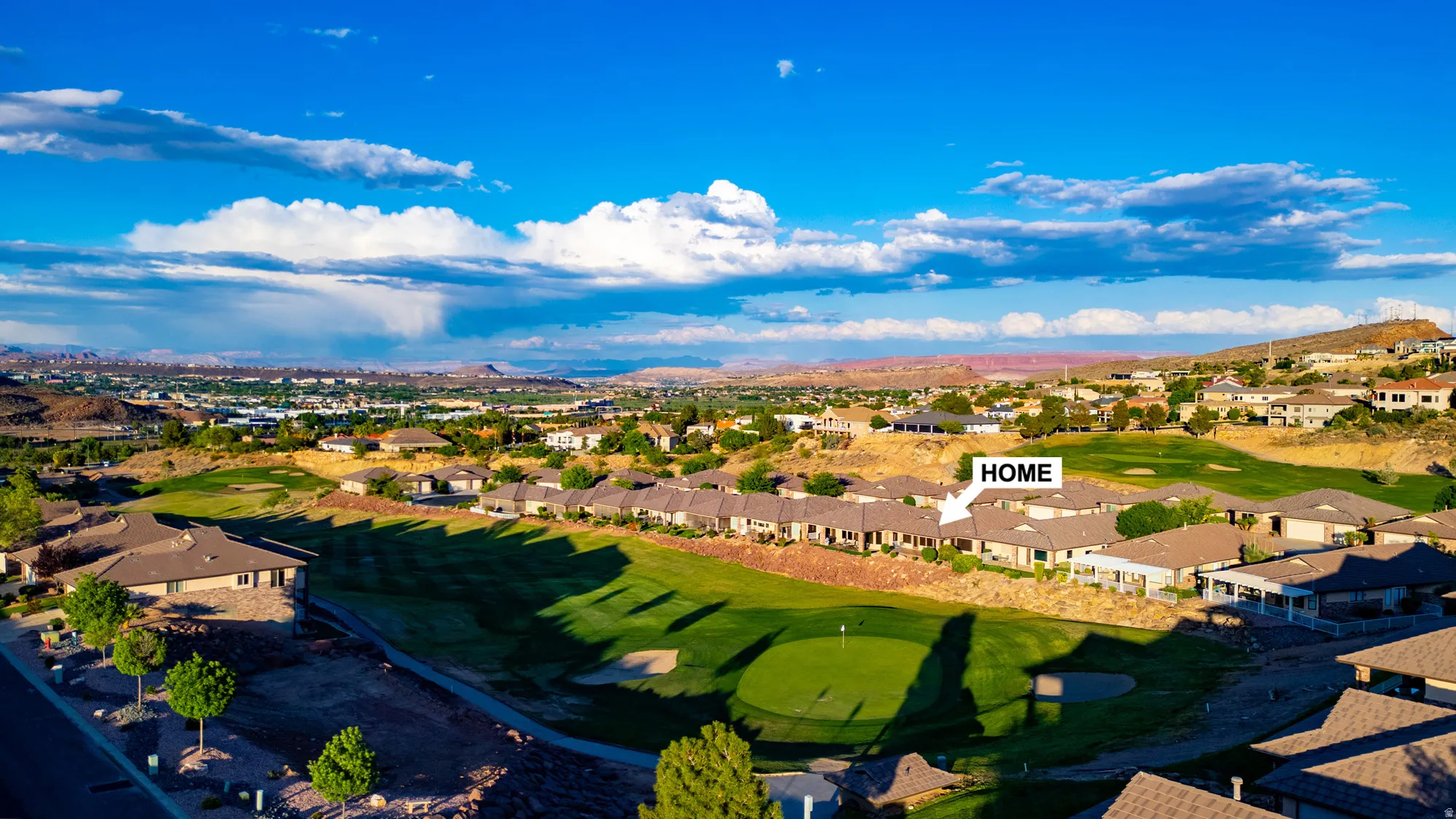 Aerial perspective of suburban area featuring a golf club and a mountain backdrop