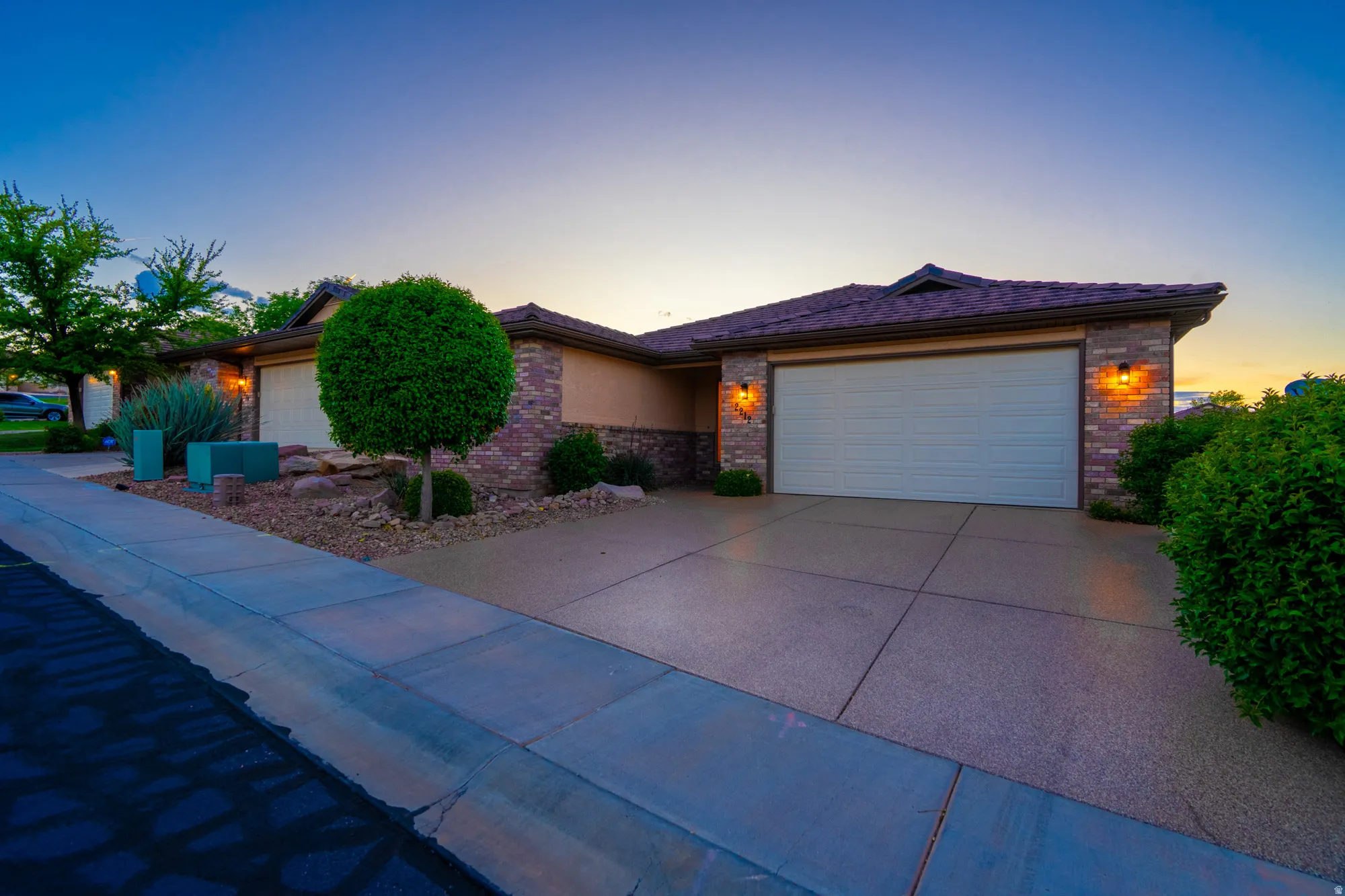 View of front of home featuring a garage, brick siding, and concrete driveway