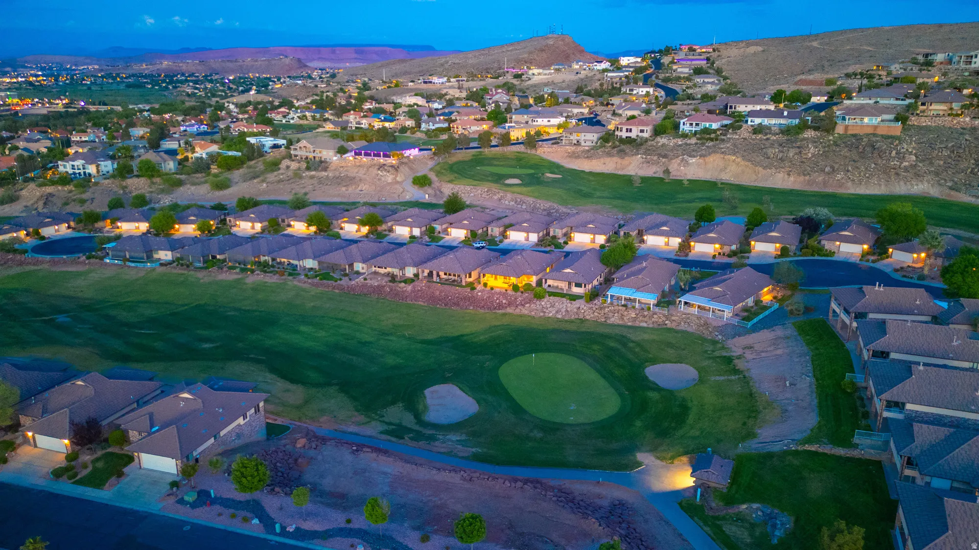 Aerial view of residential area featuring a golf club and mountains