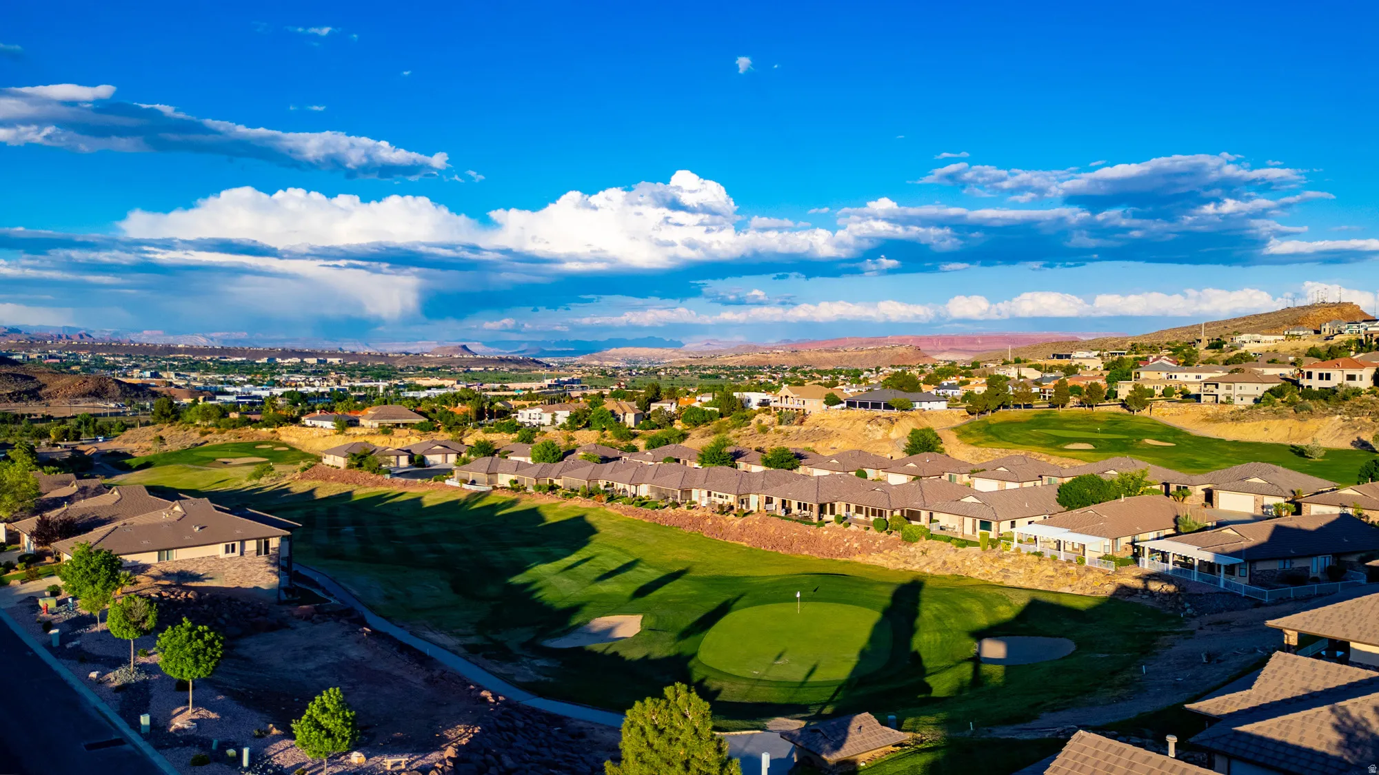 Aerial view of residential area featuring a golf club and a mountain backdrop