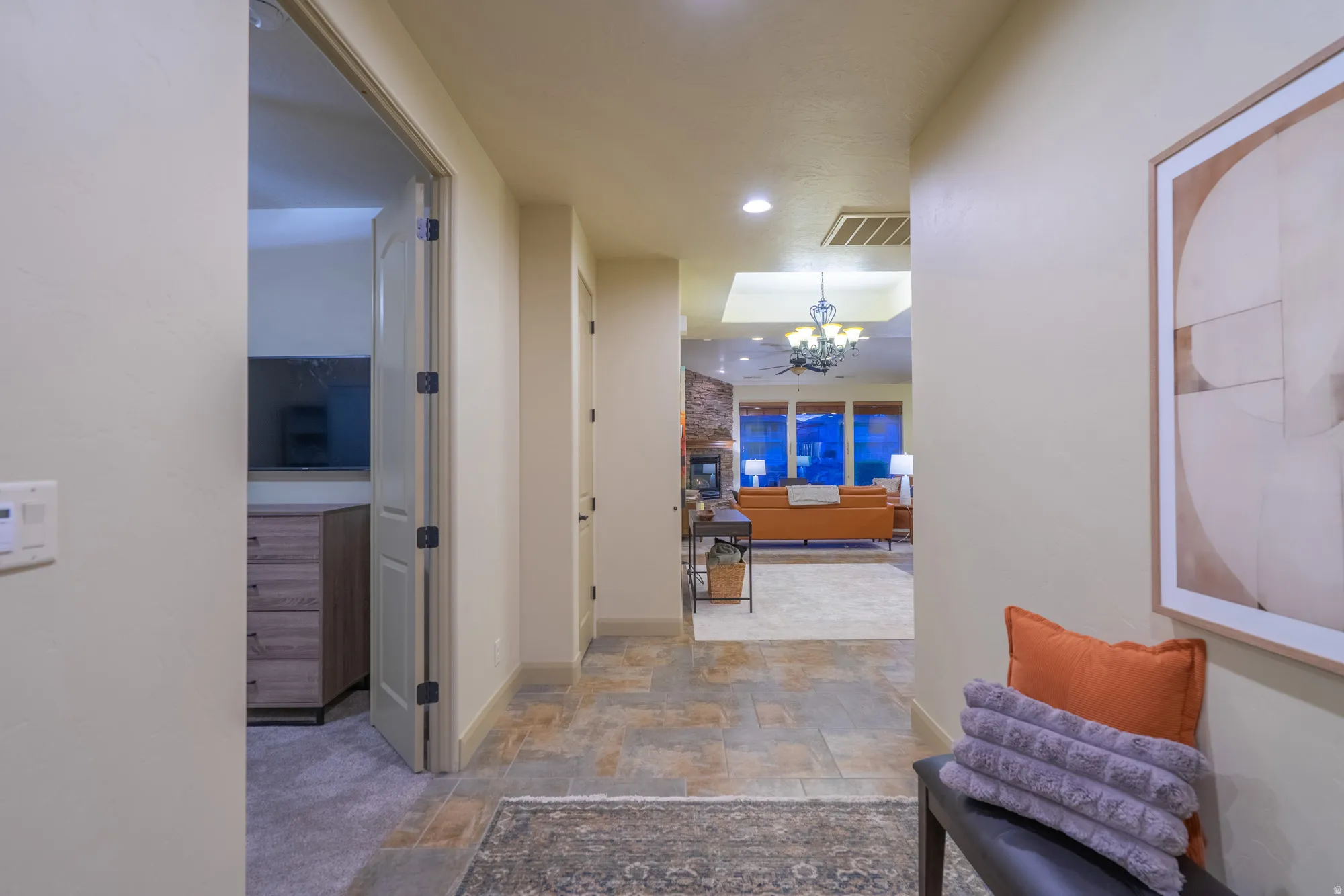 Hallway featuring stone finish floors and hanging lights