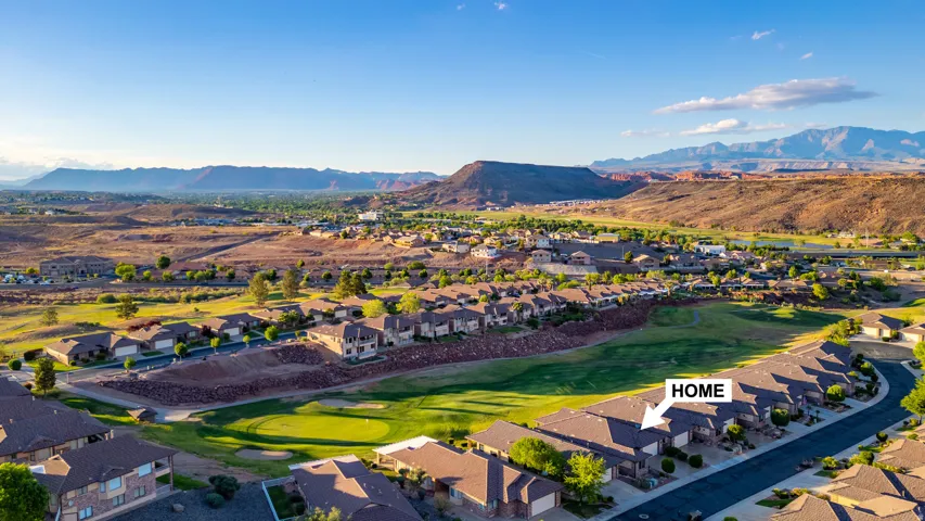 Aerial view of residential area with a mountain backdrop and a local golf course