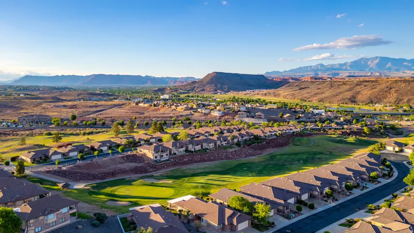 Aerial view of residential area with mountains and a golf club