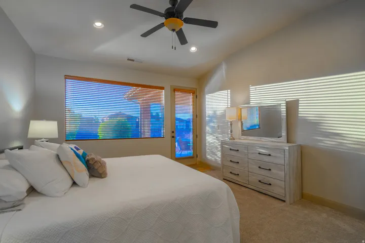 Bedroom featuring access to exterior, a ceiling fan, light carpet, vaulted ceiling, and recessed lighting