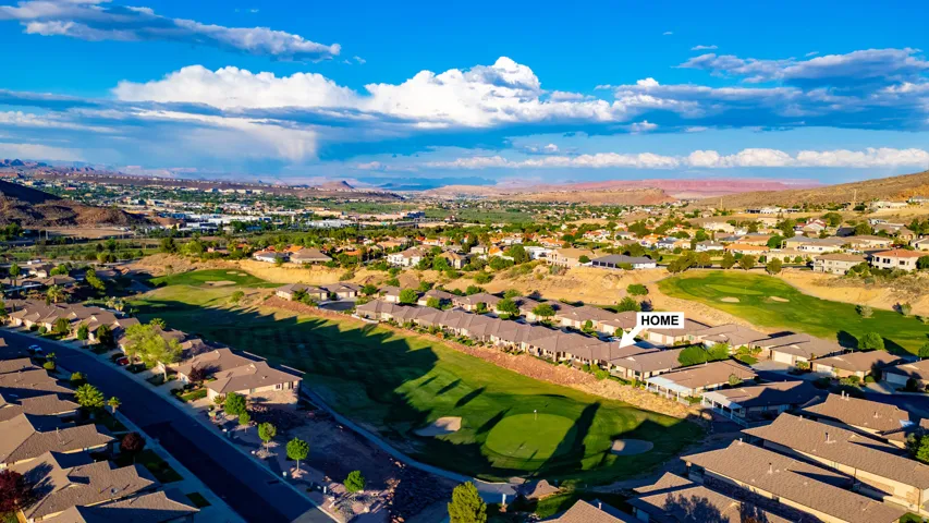 Aerial perspective of suburban area featuring a mountainous background and a golf course