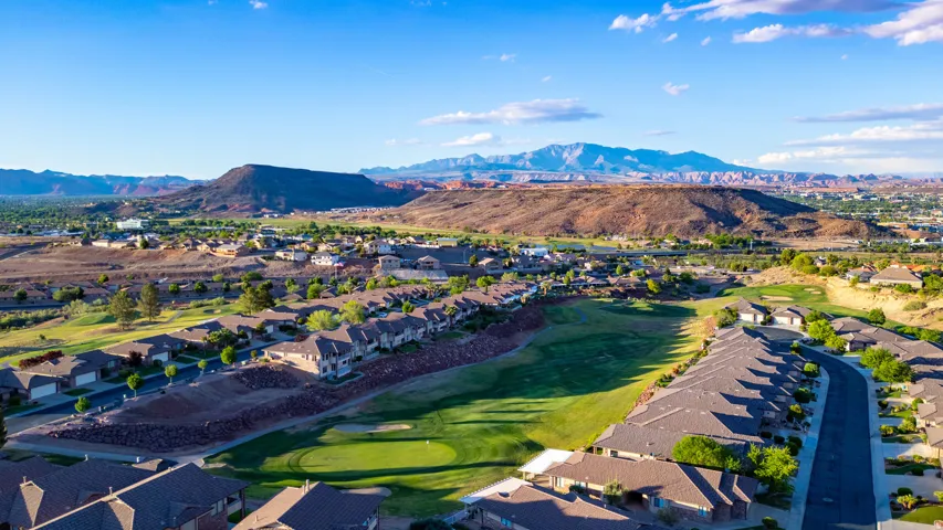 Aerial view of residential area featuring mountains and a golf course