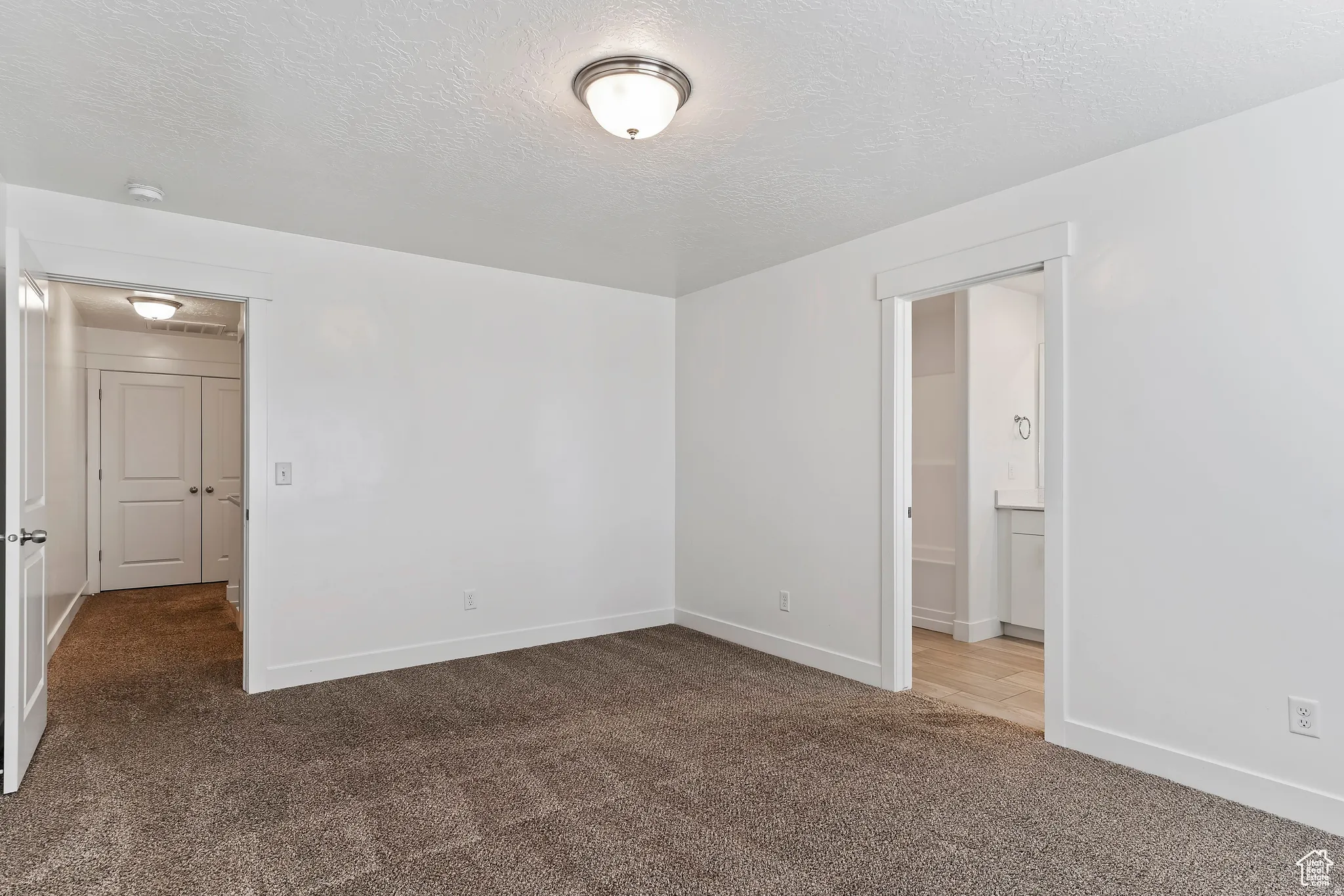 Unfurnished room with carpet flooring and a textured ceiling