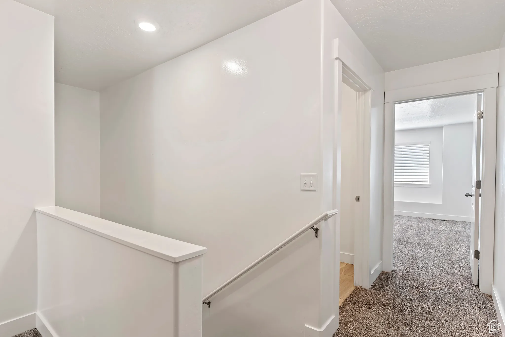 Hallway featuring an upstairs landing and carpet floors