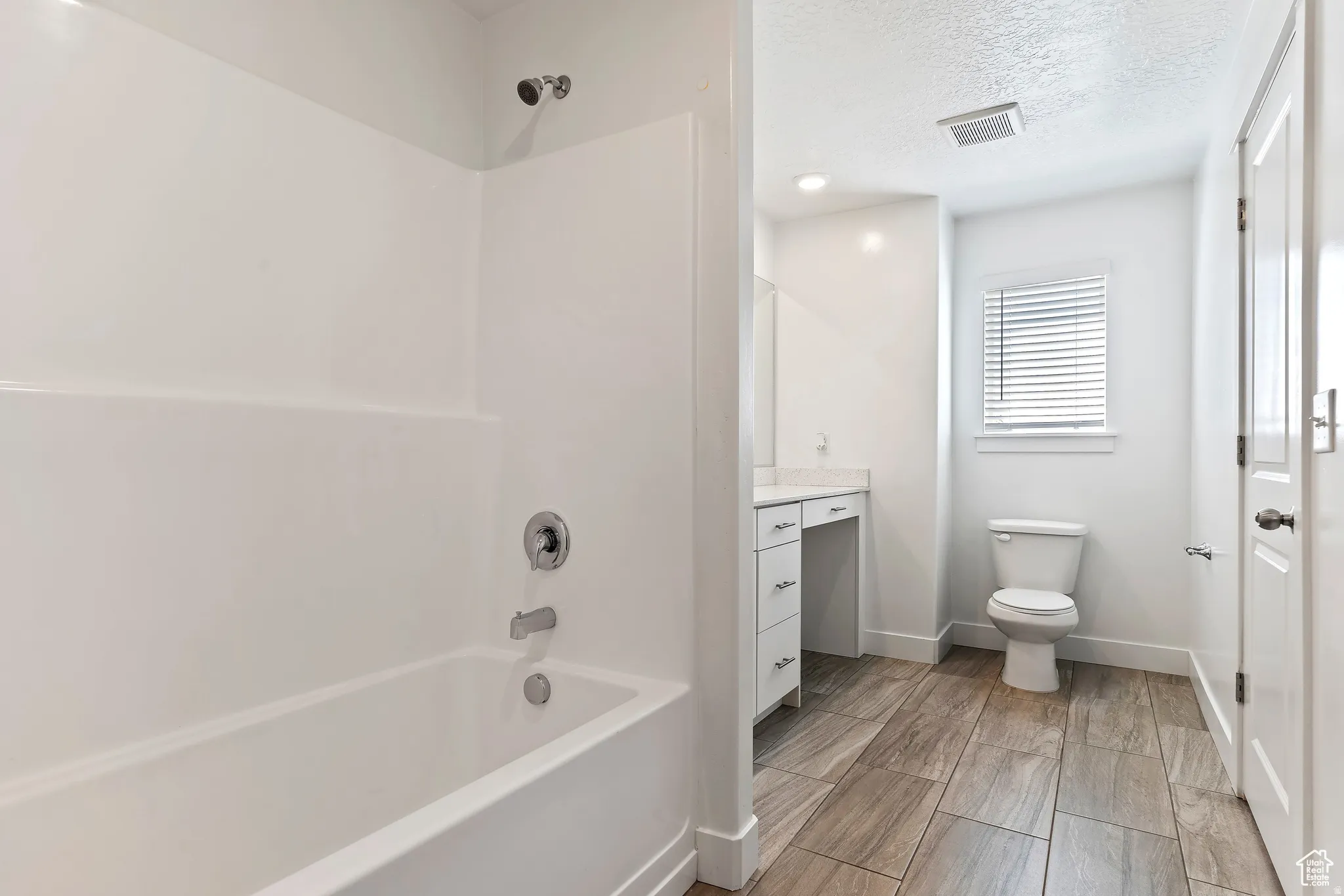 Full bathroom featuring washtub / shower combination, a textured ceiling, and vanity