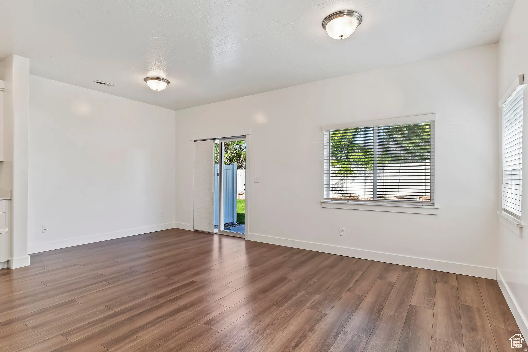 Spare room featuring baseboards and dark wood-style floors