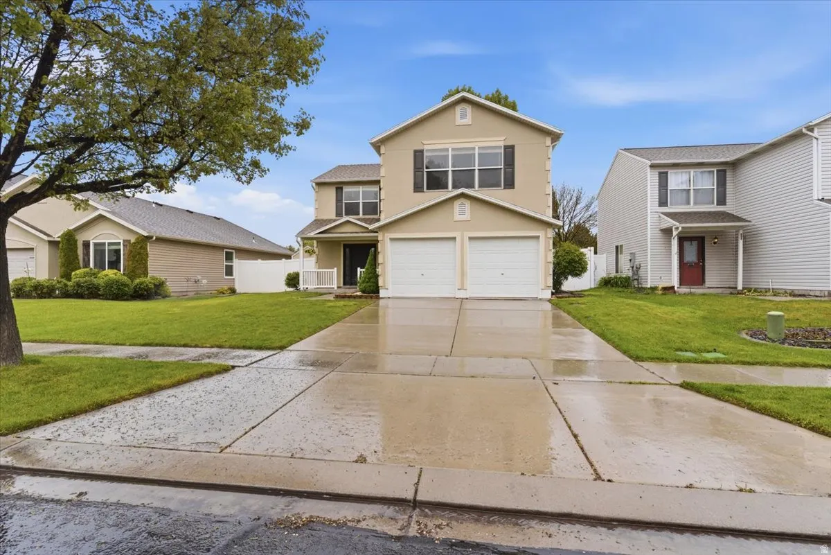 Traditional home featuring driveway, stucco siding, and an attached garage