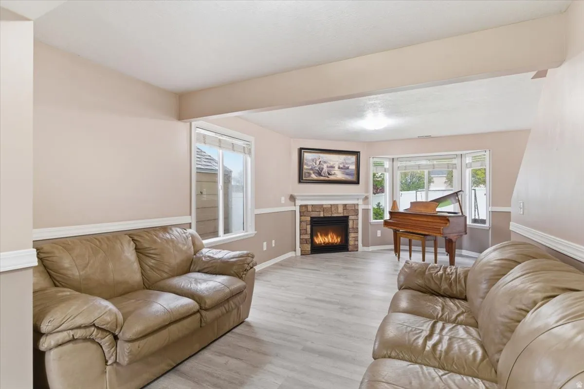 Living room featuring light wood finished floors and a stone fireplace