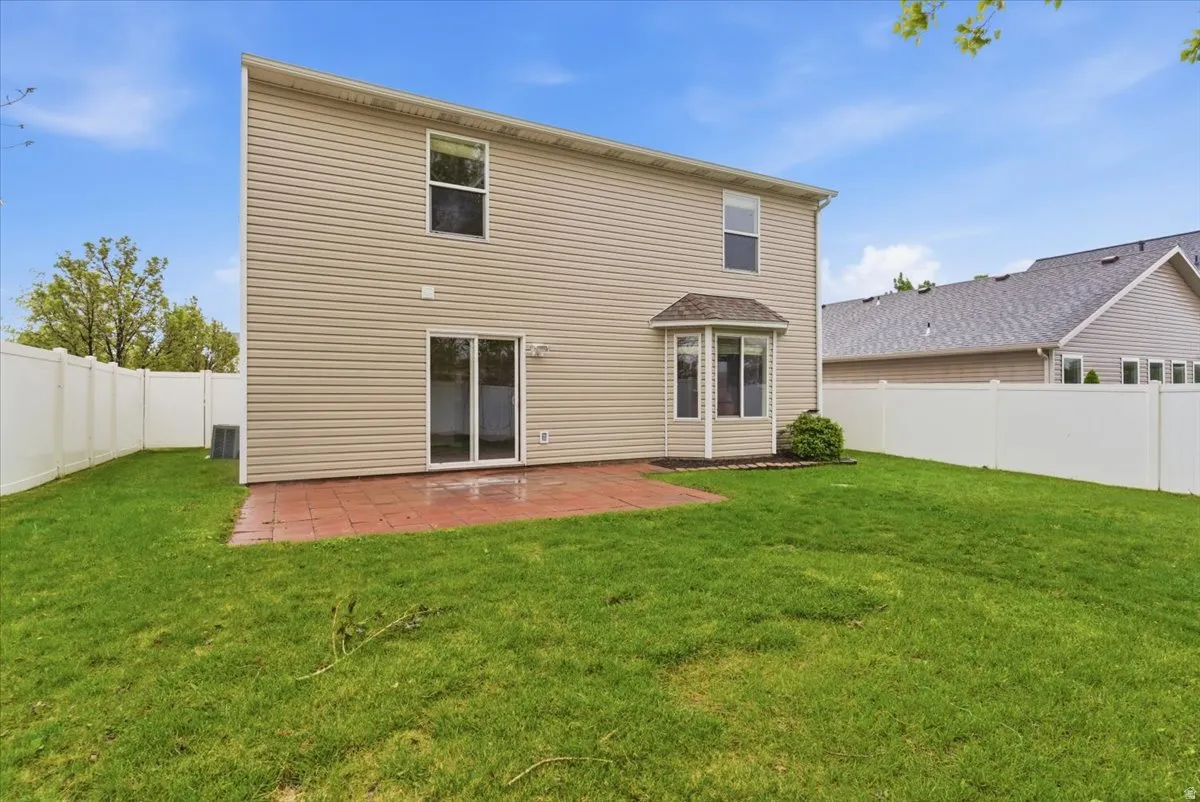 Rear view of property featuring a patio and a fenced backyard