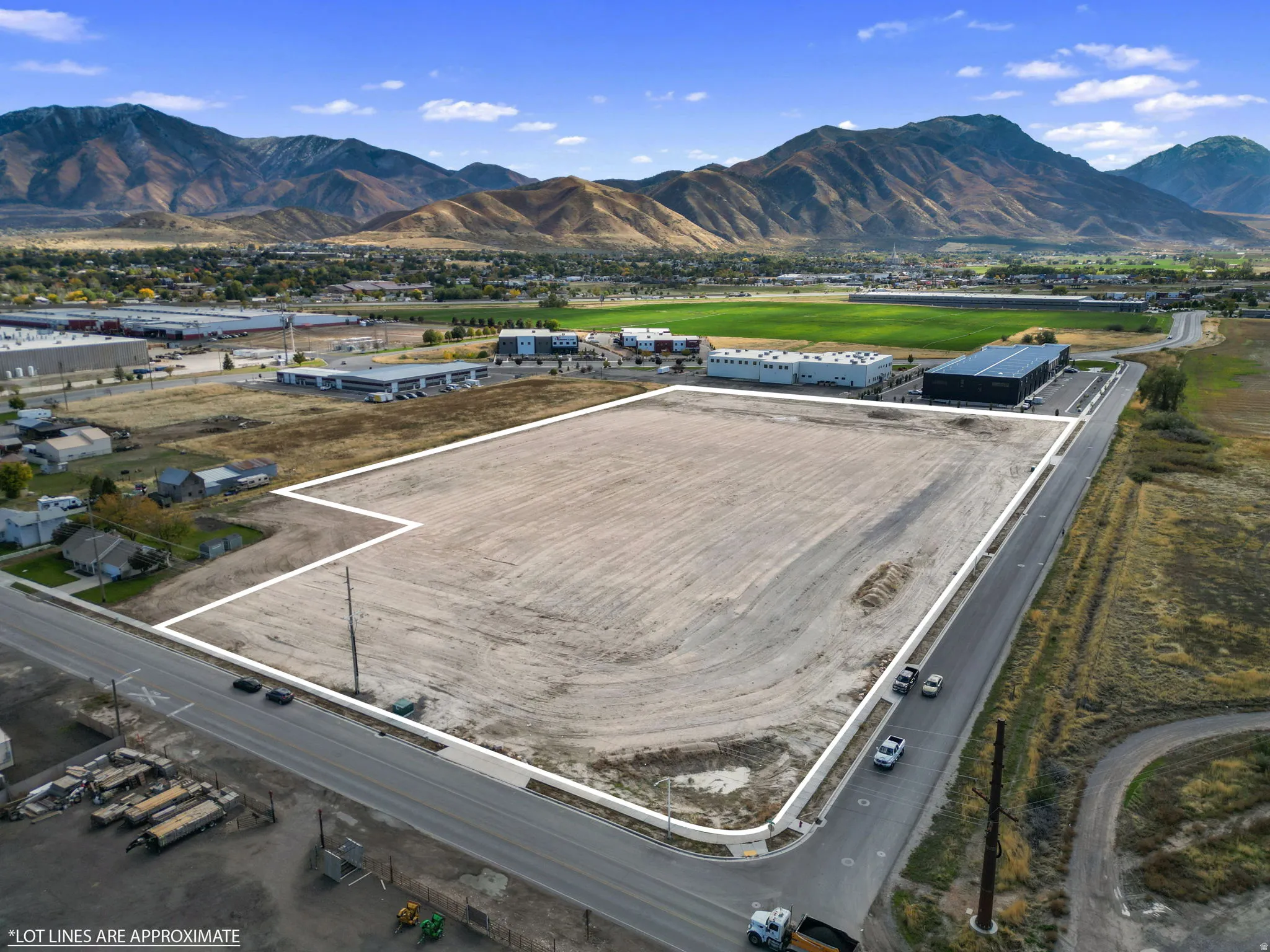 Aerial view of property and surrounding area featuring a mountainous background and property parcel outlined