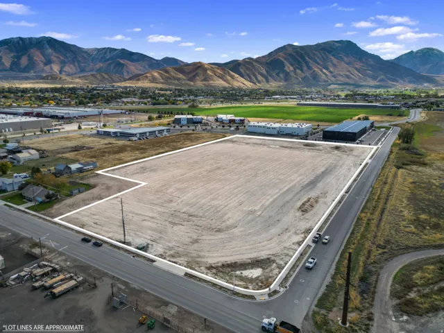 Aerial view of property and surrounding area featuring a mountainous background and property parcel outlined