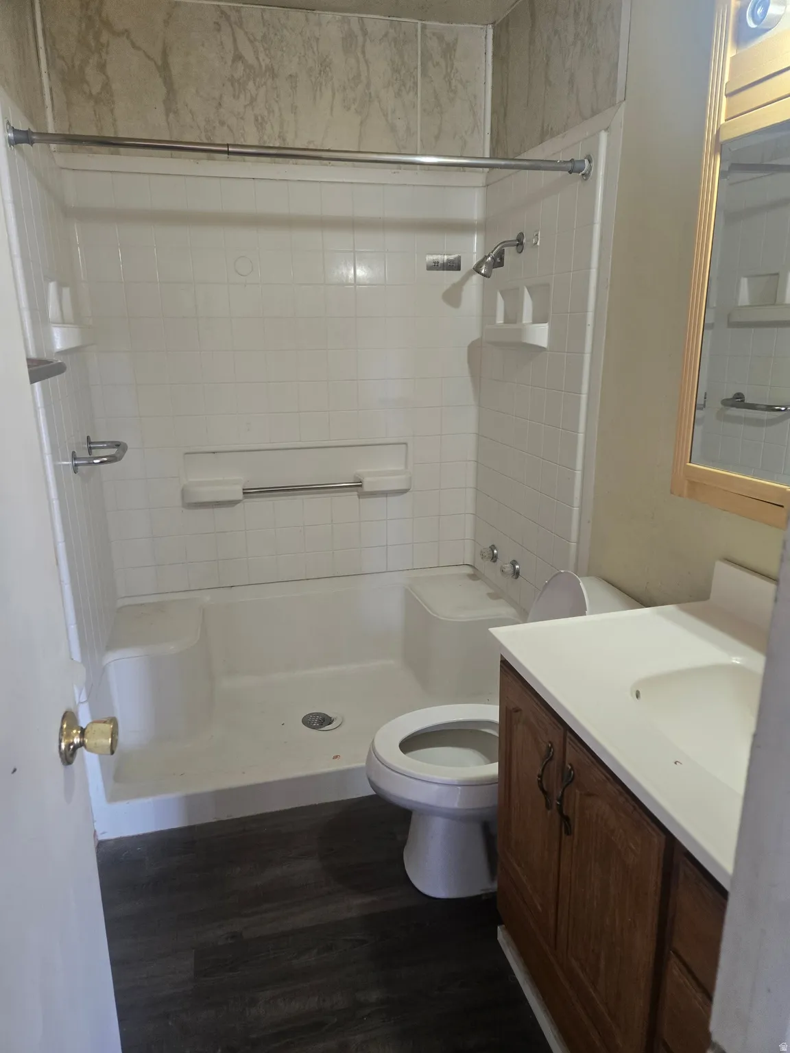 Full bathroom featuring vanity, a shower stall, and dark wood-style floors