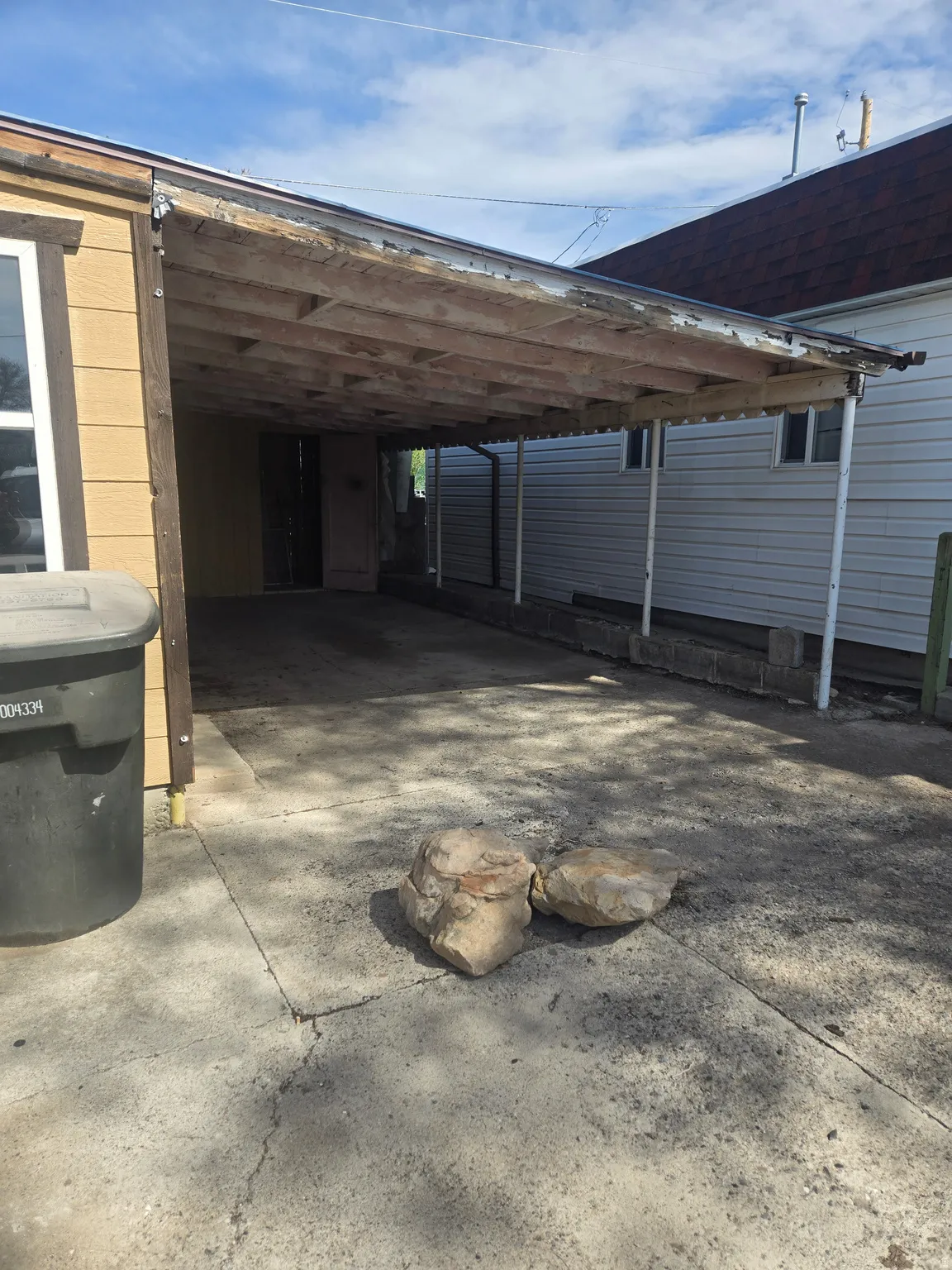 View of parking with a carport and driveway