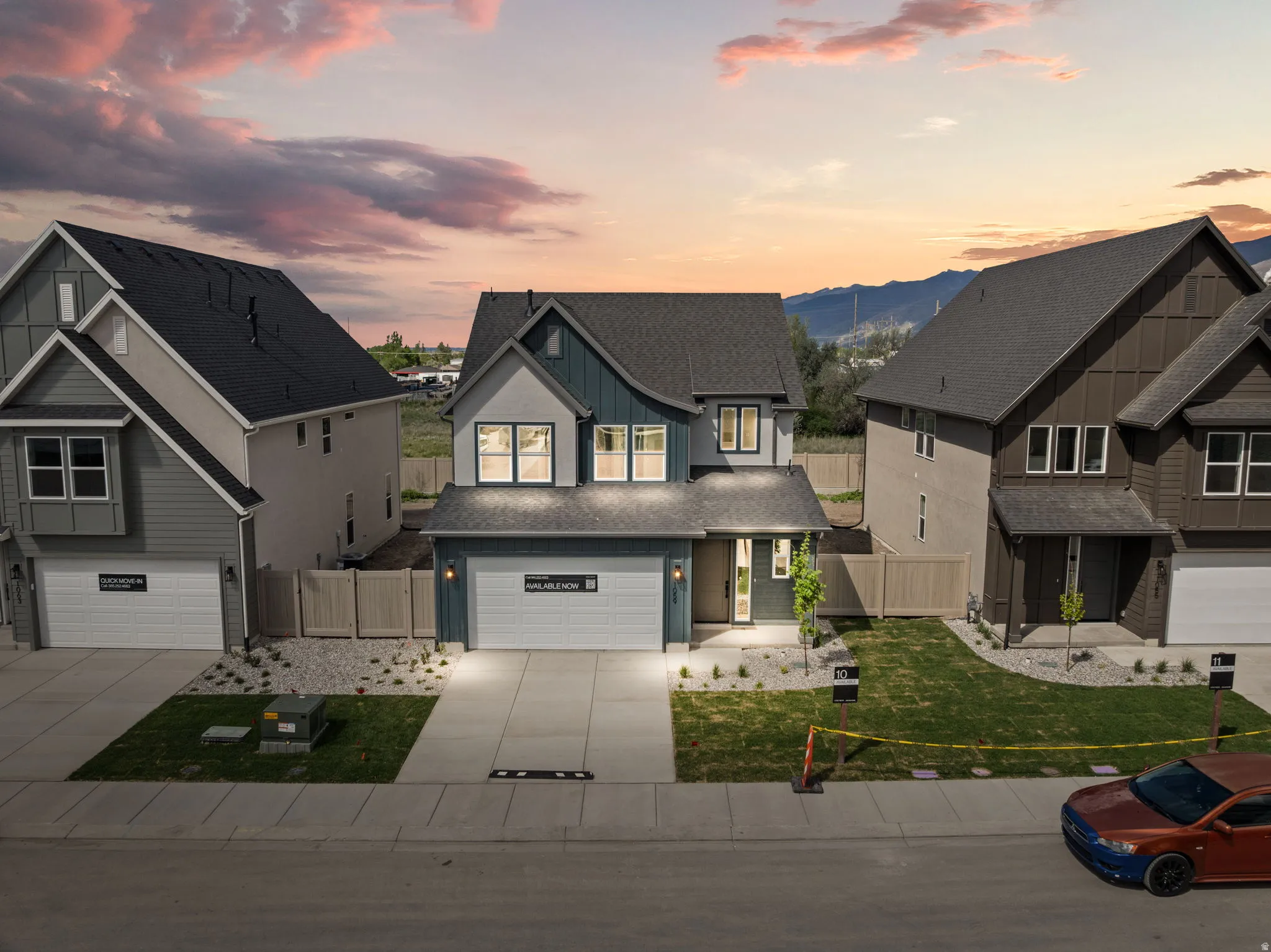 View of front facade with a gate, an attached garage, concrete driveway, and board and batten siding