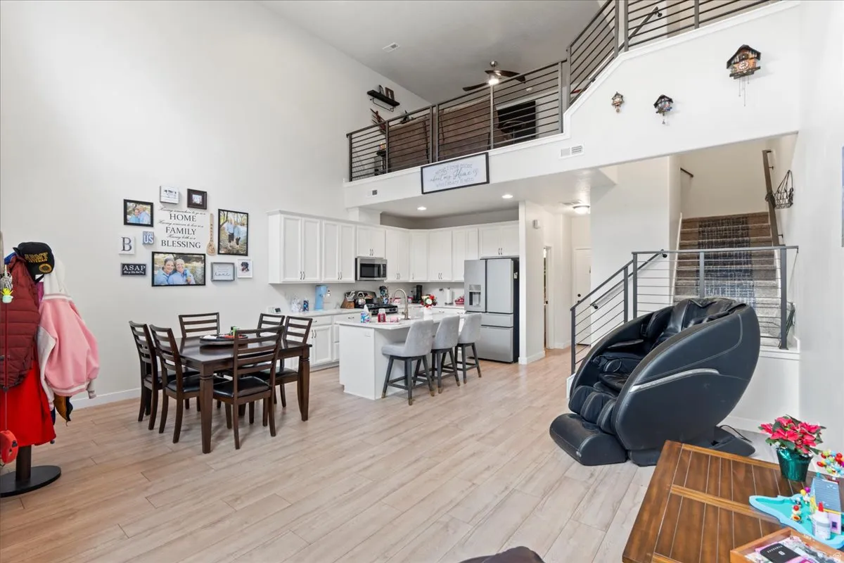 Living room featuring a high ceiling, light wood finished floors, and recessed lighting