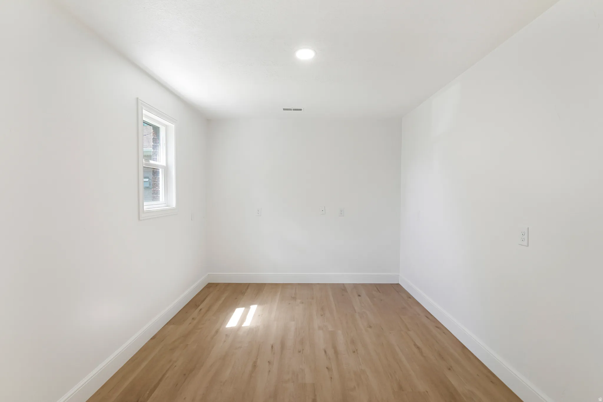 Unfurnished room featuring baseboards and light wood-style floors