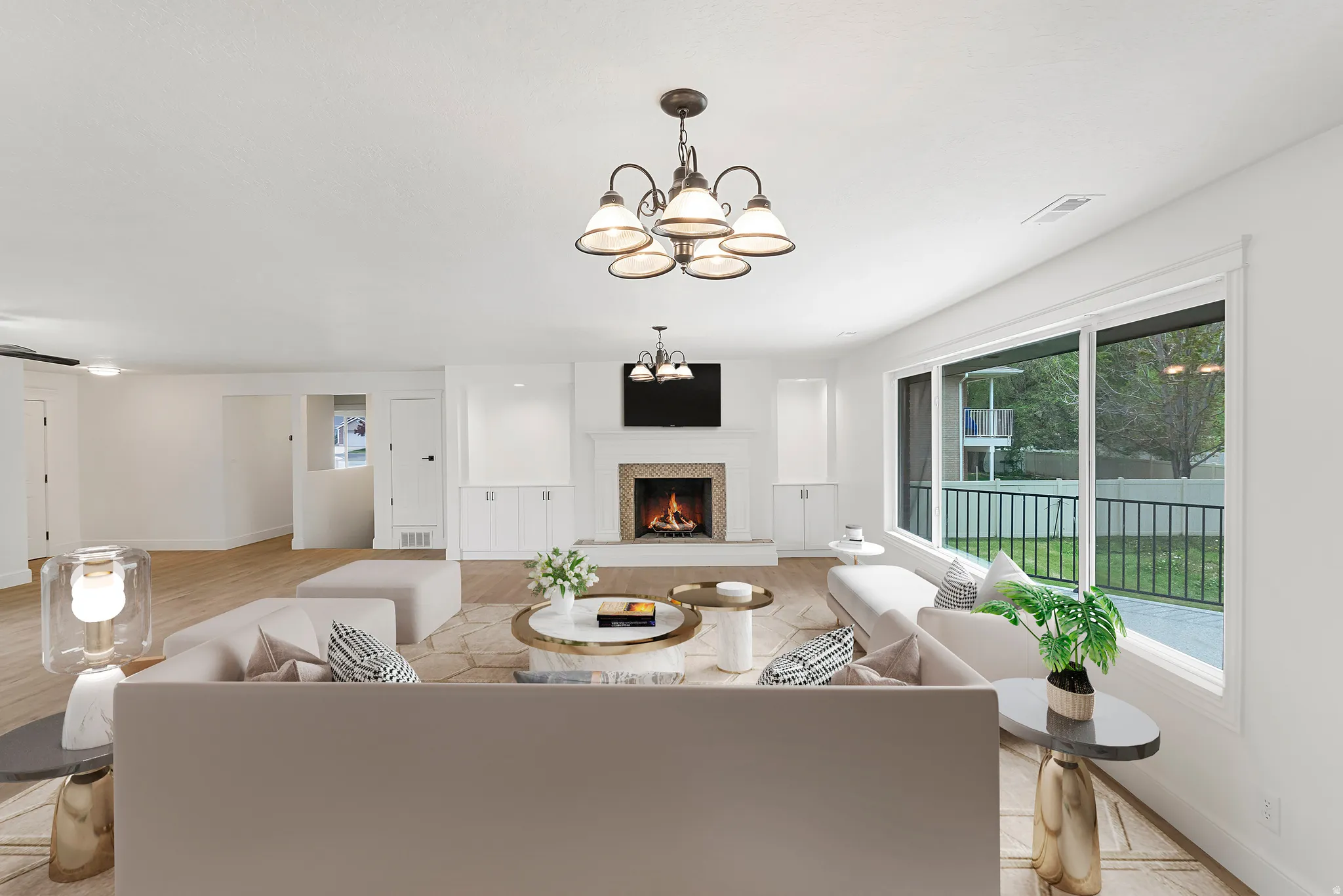 Living room featuring a chandelier, a warm lit fireplace, and light wood-type flooring