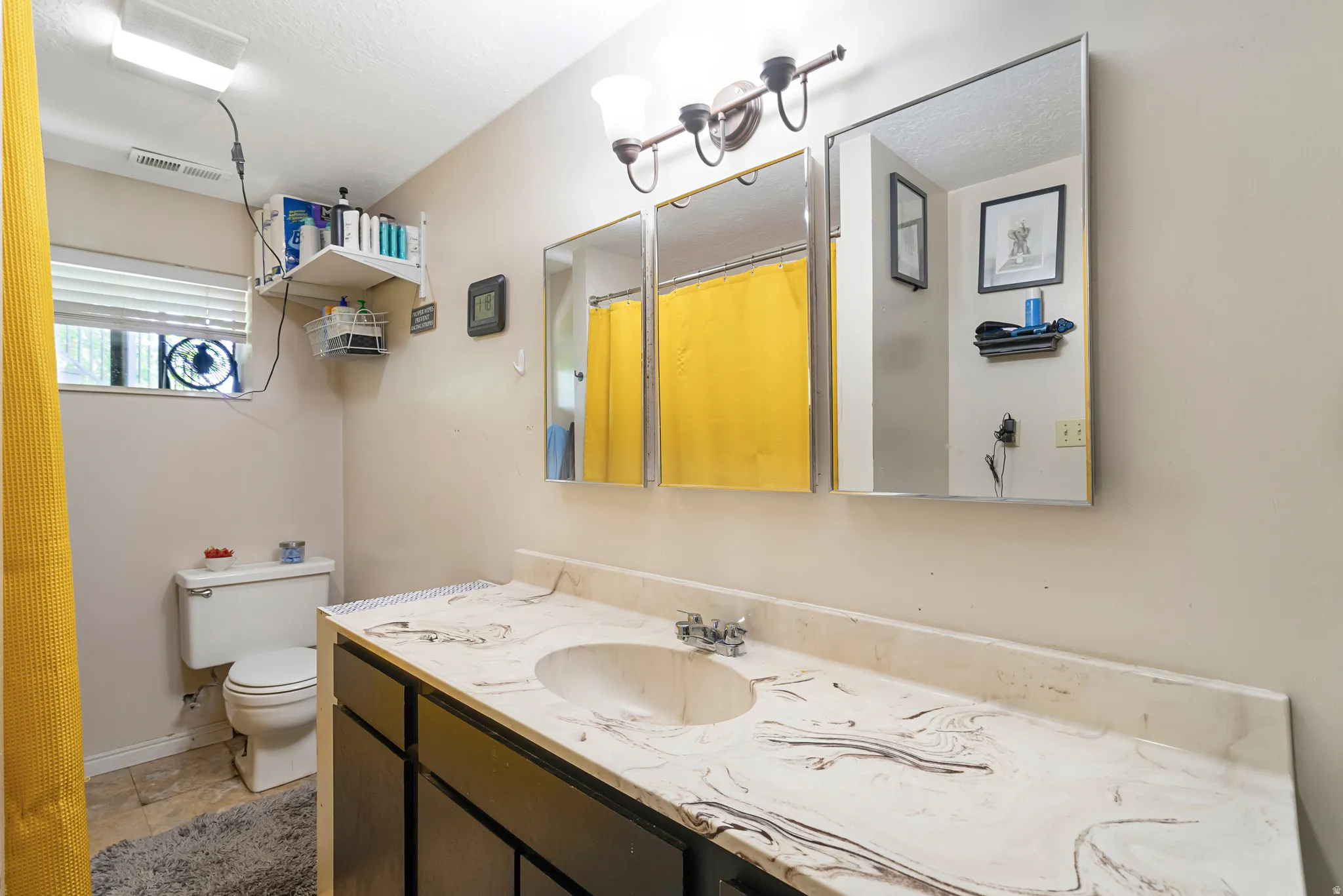 Bathroom featuring a shower with curtain and vanity