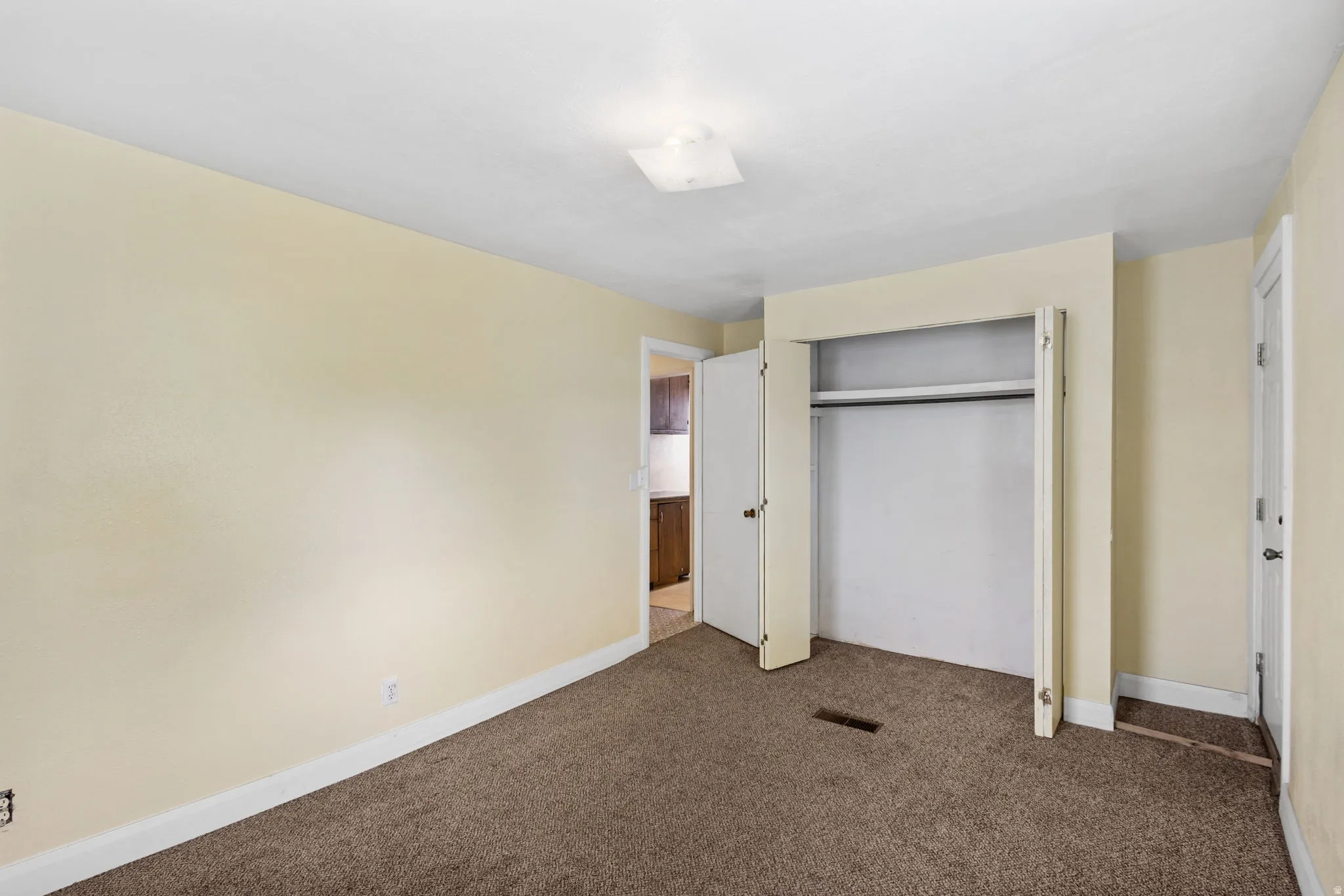 Unfurnished bedroom featuring carpet flooring and a closet