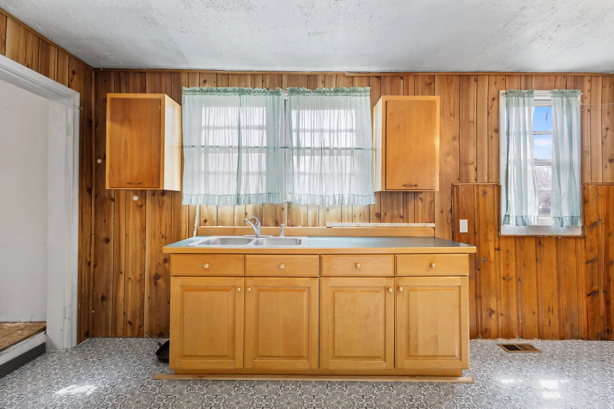 Kitchen with wood walls, light countertops, and wood finish cabinets