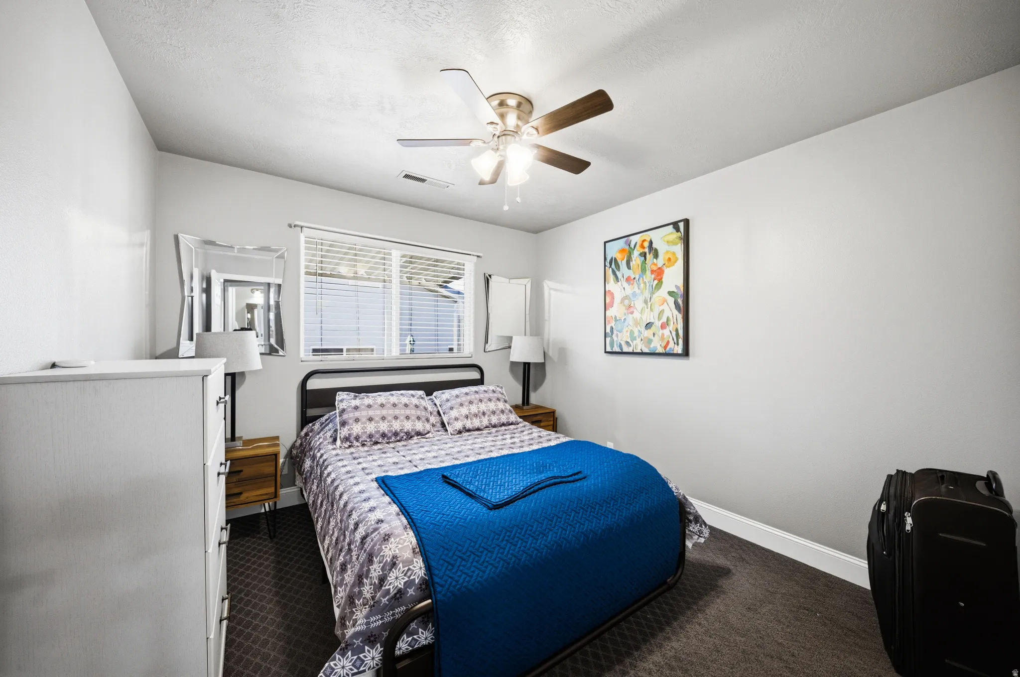 Carpeted bedroom featuring baseboards and ceiling fan