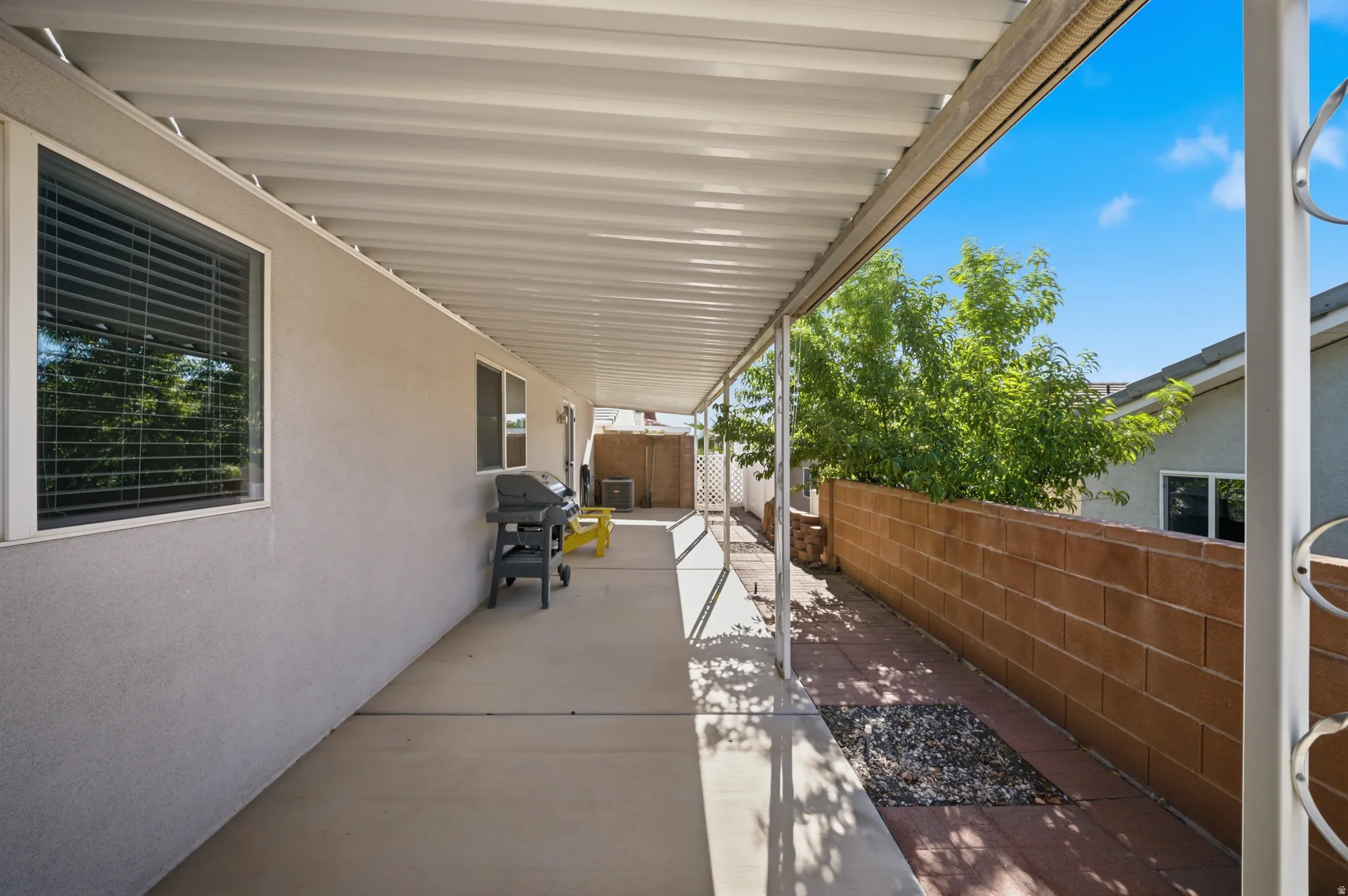 View of patio with a grill