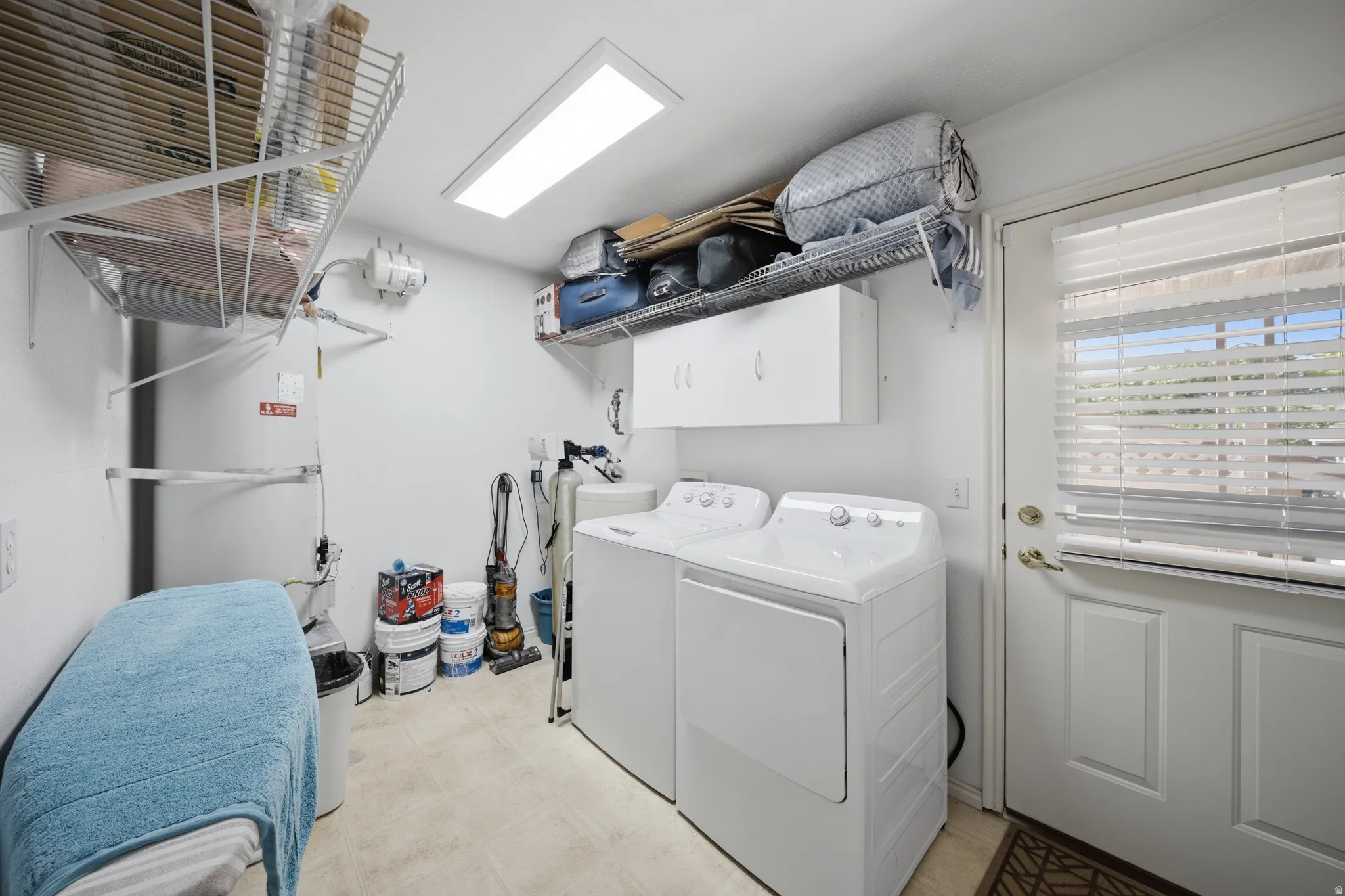 Laundry room with cabinet space, light flooring, and separate washer and dryer