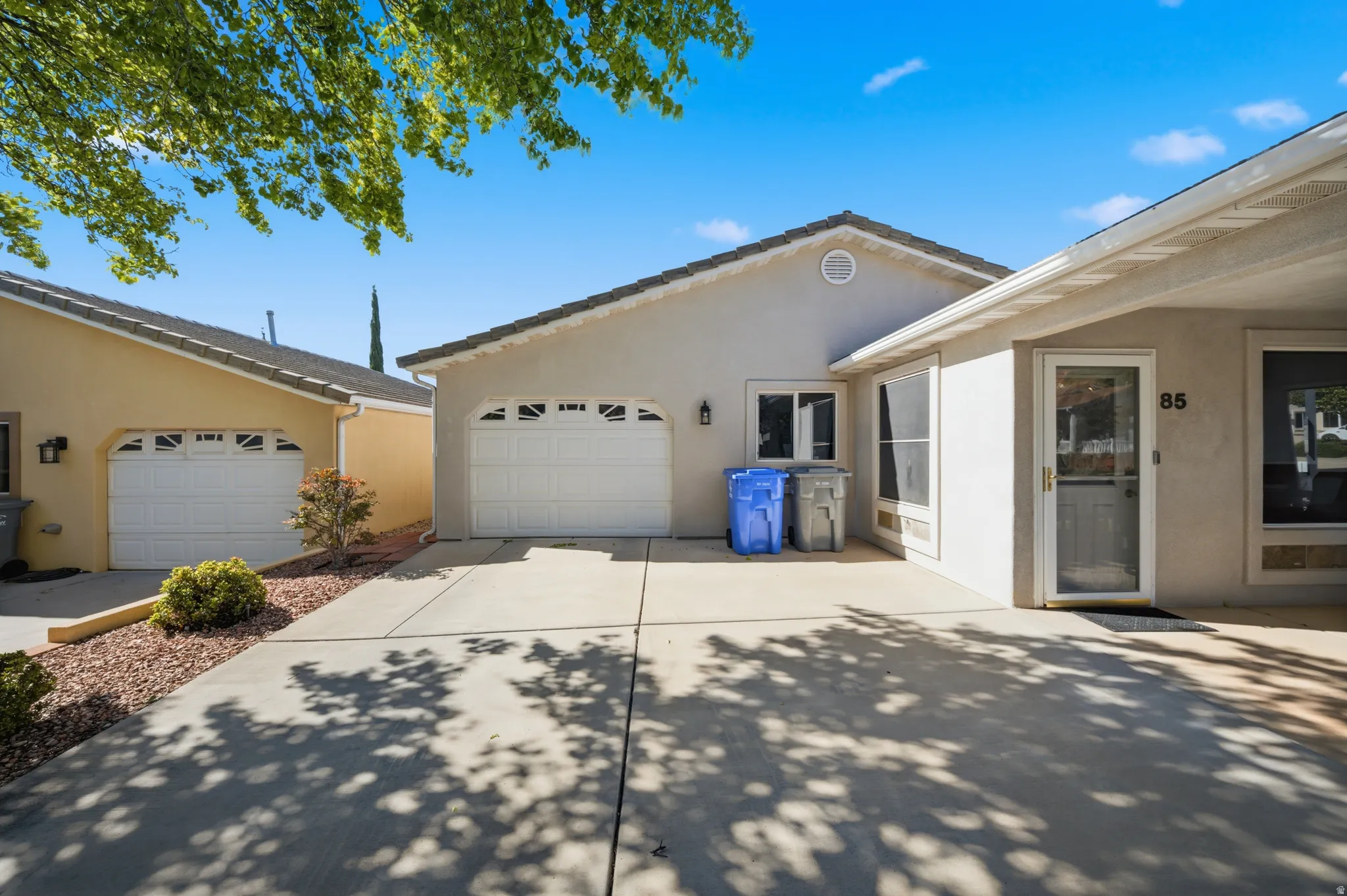 View of side of property with stucco siding, driveway, and a garage