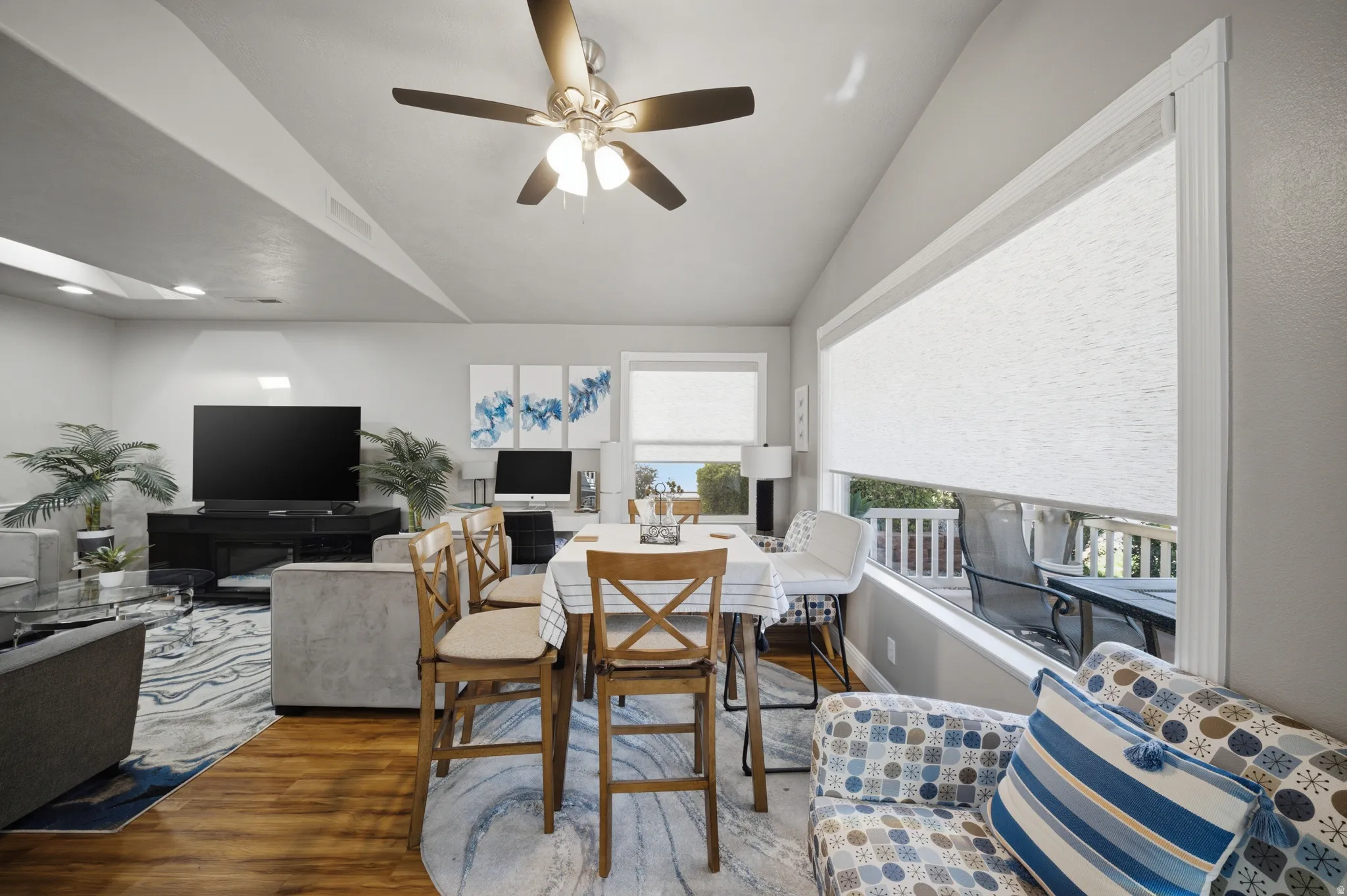 Dining room with a ceiling fan, wood finished floors, and lofted ceiling