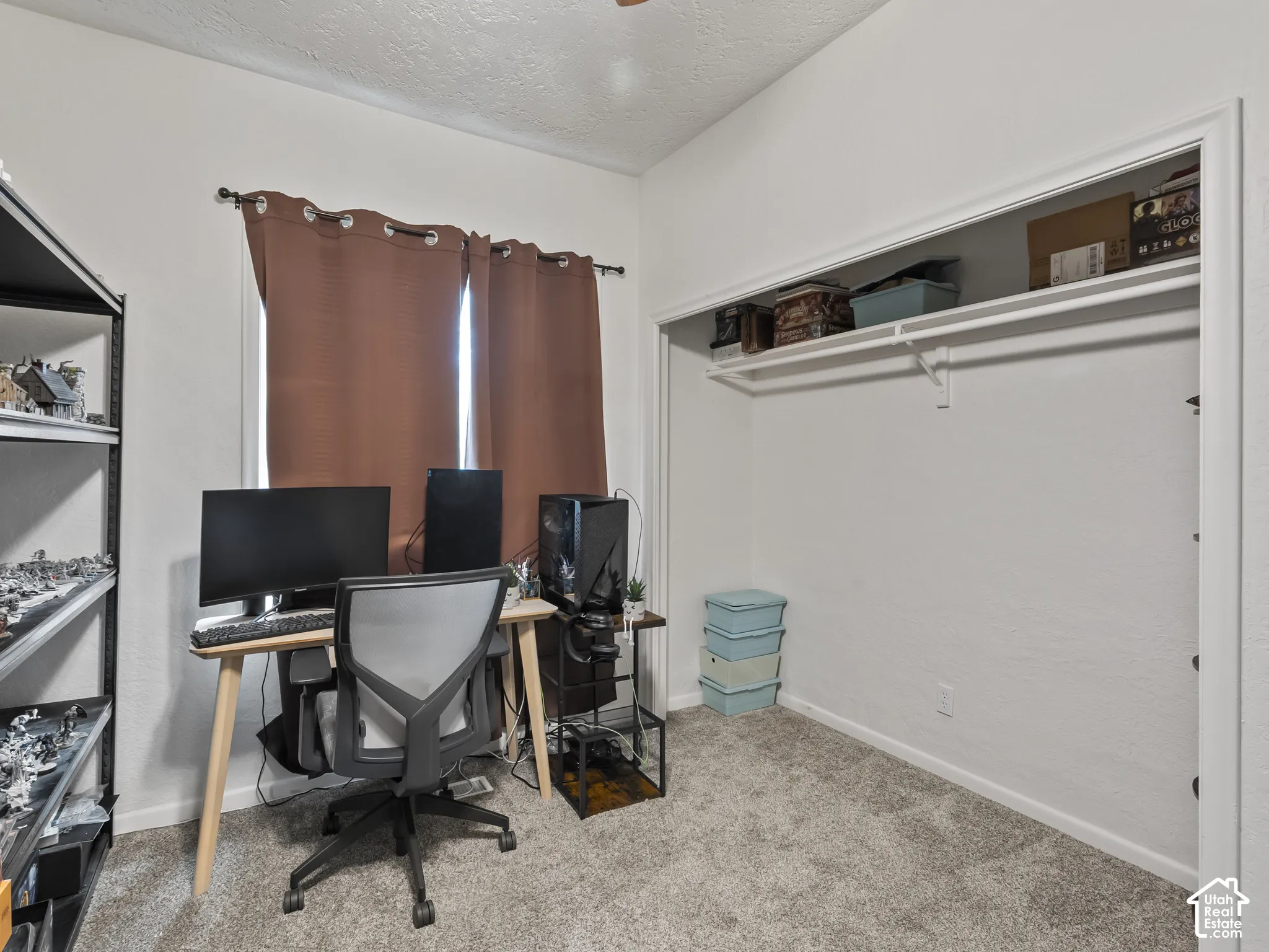 Office area with a textured ceiling and light colored carpet