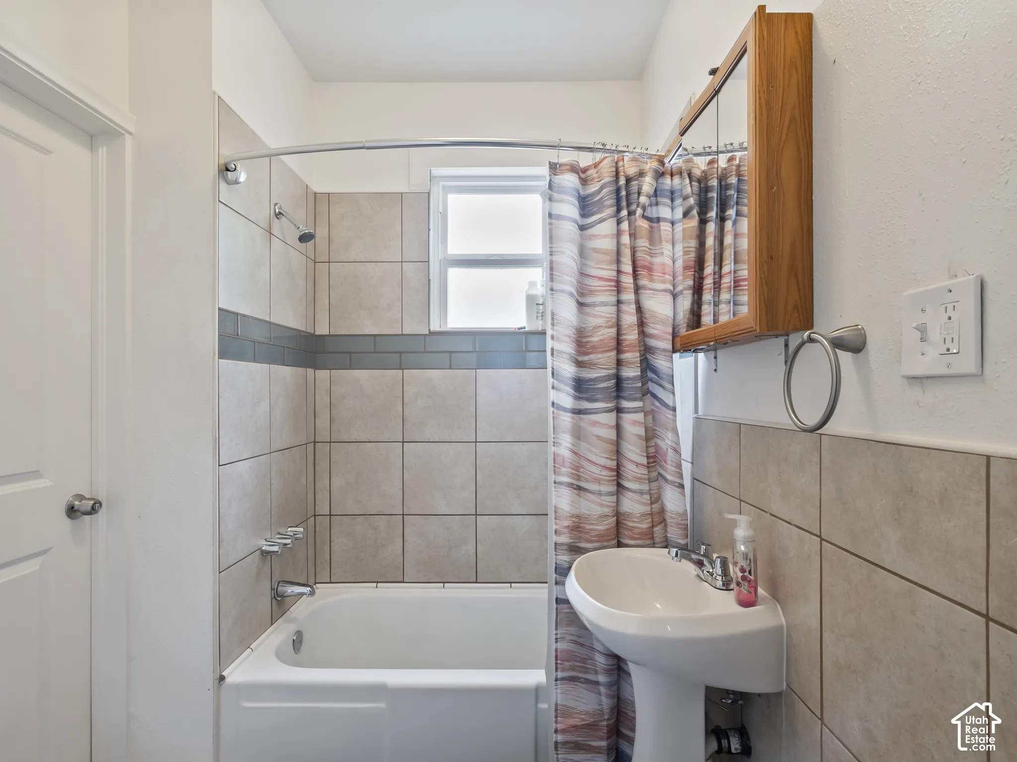 Bathroom with shower / bath combo with shower curtain and tile walls