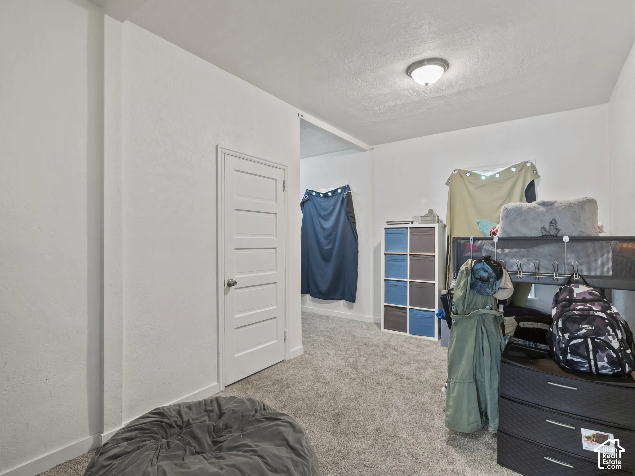 Bedroom featuring carpet flooring, a textured ceiling, and a textured wall