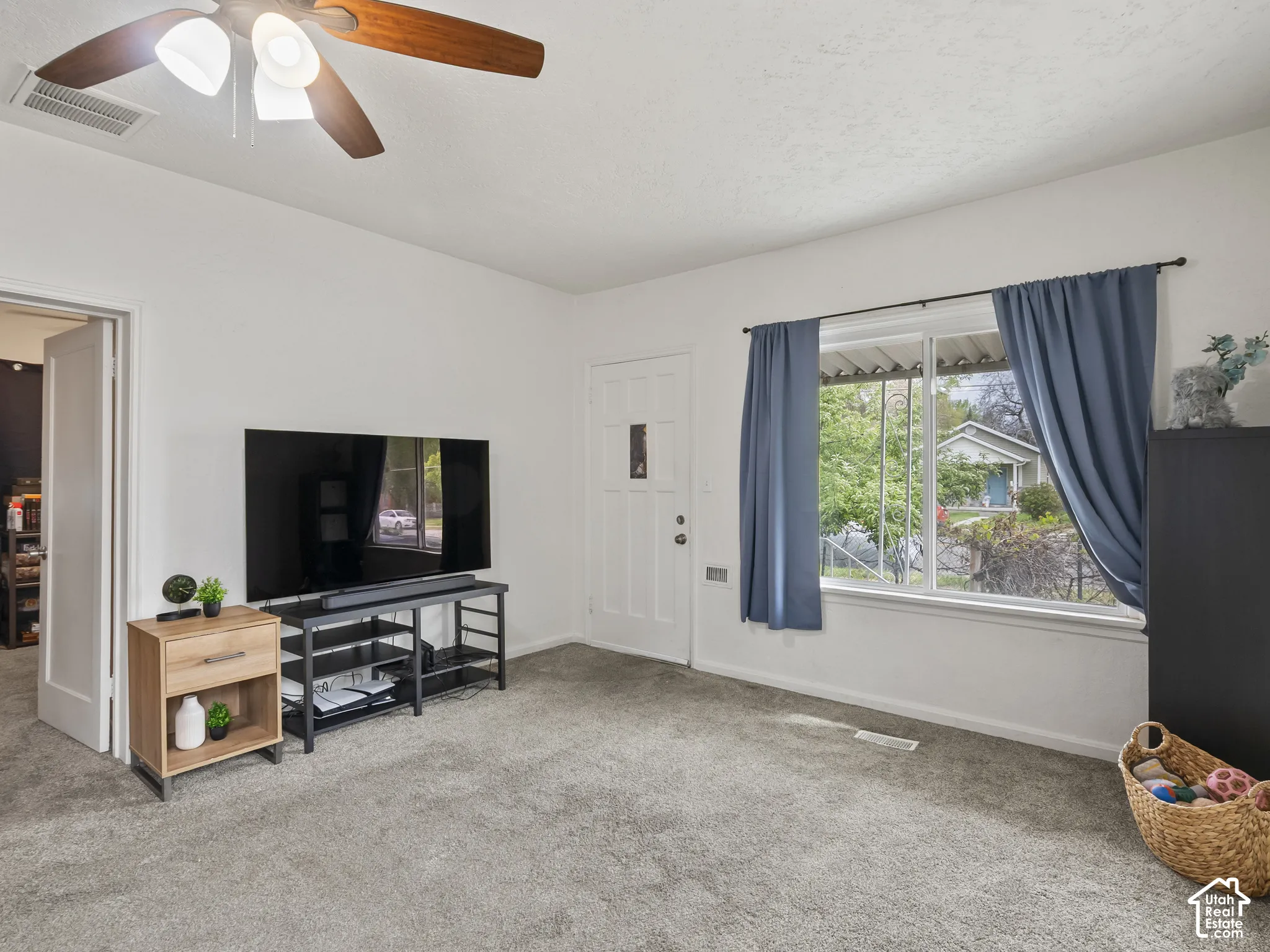 Living area featuring carpet flooring and ceiling fan