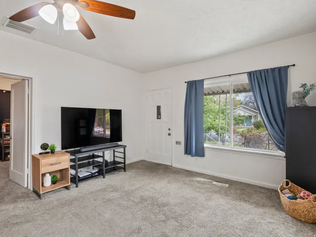 Living area featuring carpet flooring and ceiling fan