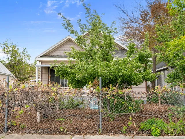 View of front of home featuring a fenced front yard and roof with shingles