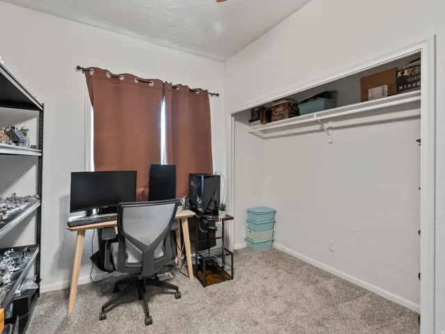 Office area with a textured ceiling and light colored carpet
