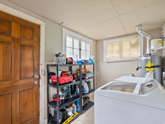 Laundry area featuring strapped water heater and separate washer and dryer