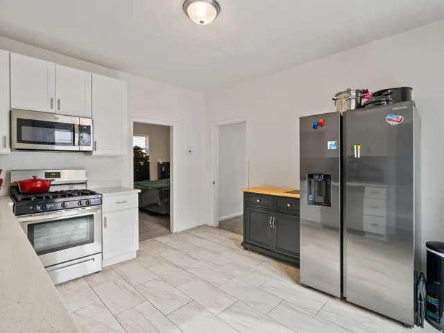 Kitchen with stainless steel appliances, wooden counters, and white cabinetry